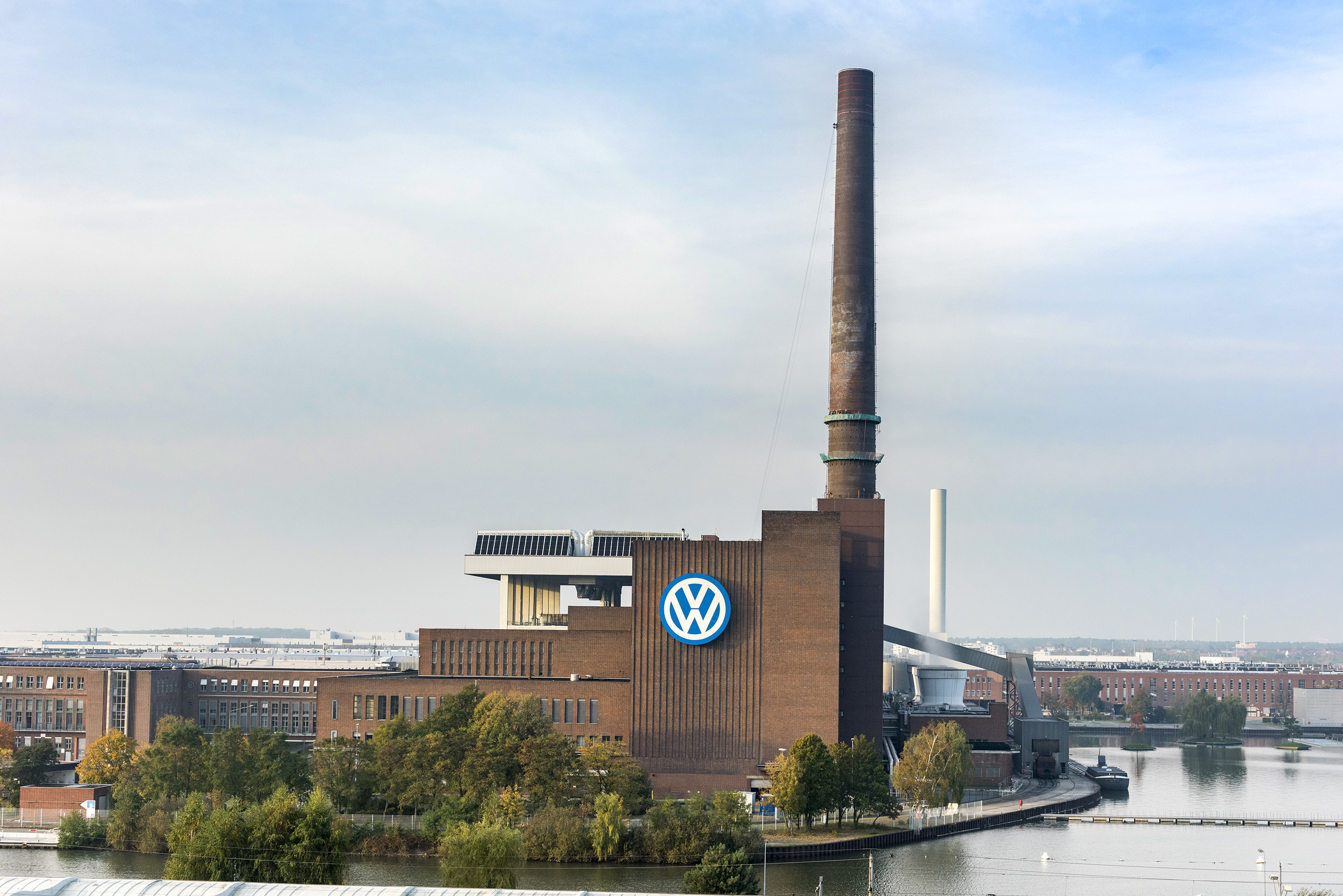VW Wolfsburg plant, large logo on brick factory building with tall smokestack.
