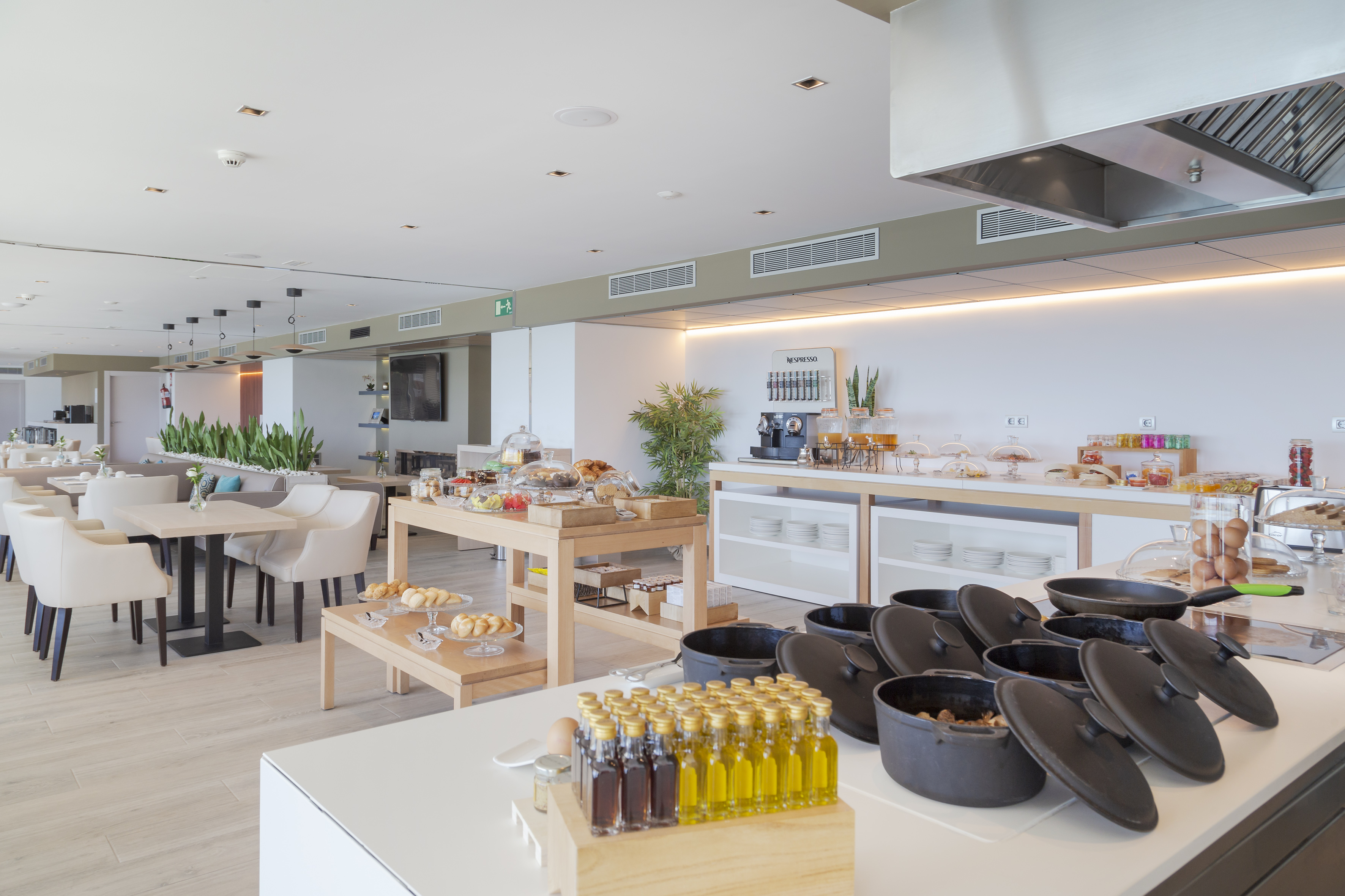 Hotel breakfast buffet with fresh food, coffee, and modern dining area.