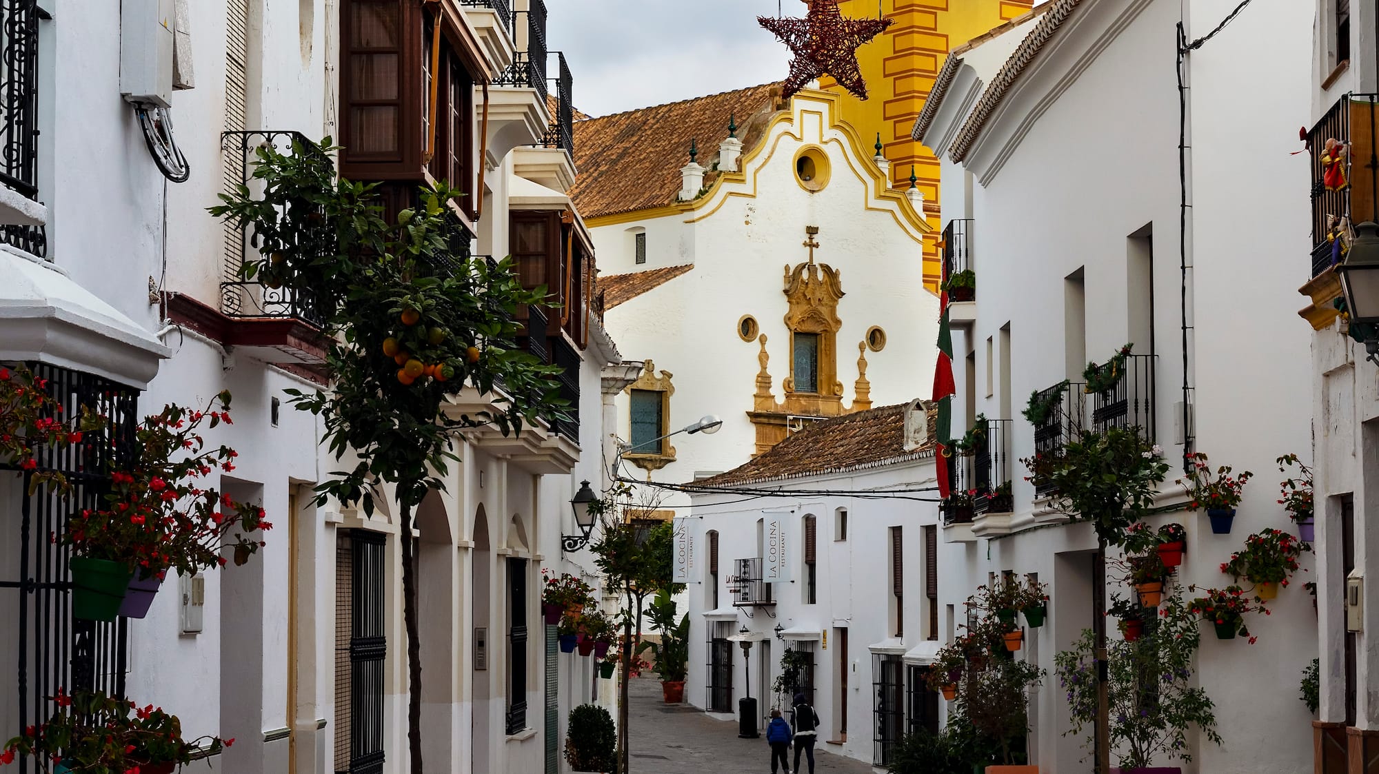 a street with white buildings and a yellow tower
