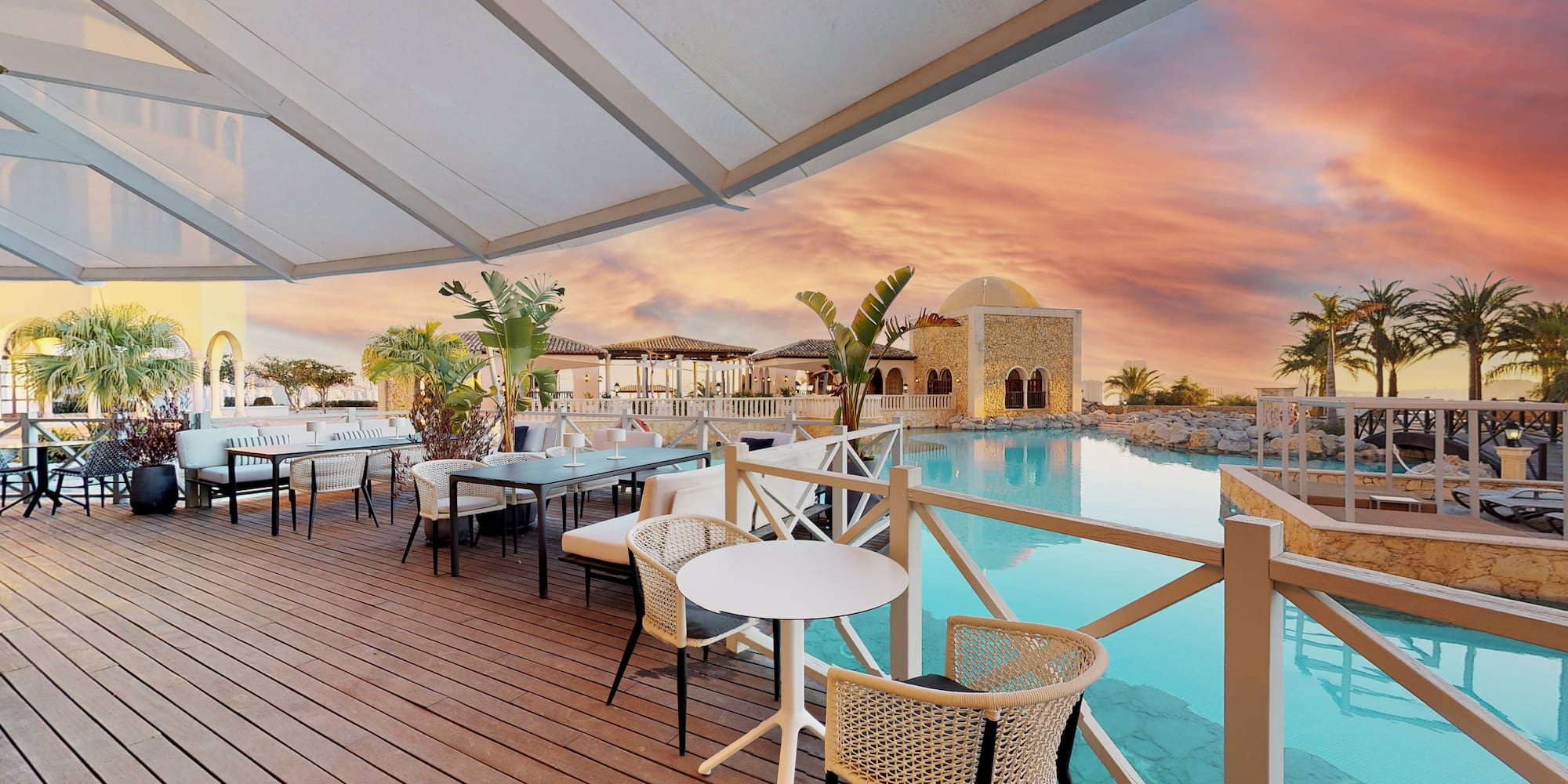 a patio with tables and chairs and a pool