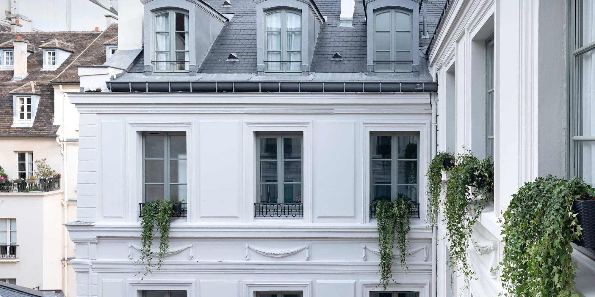 a white building with plants on the side