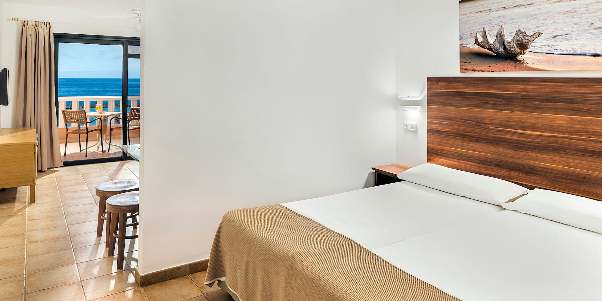 a room with a bed and a view of the ocean