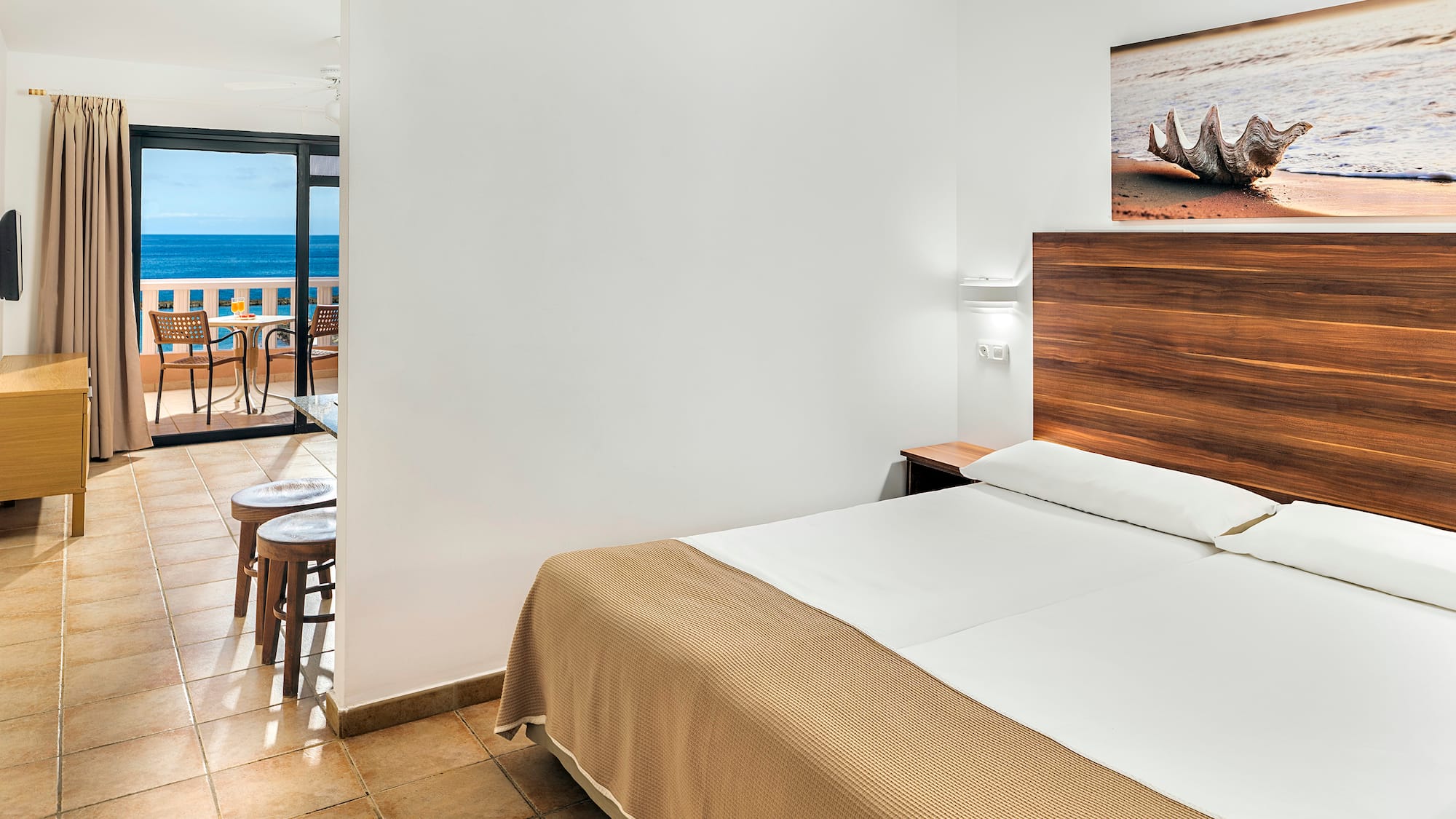 a room with a bed and a view of the ocean