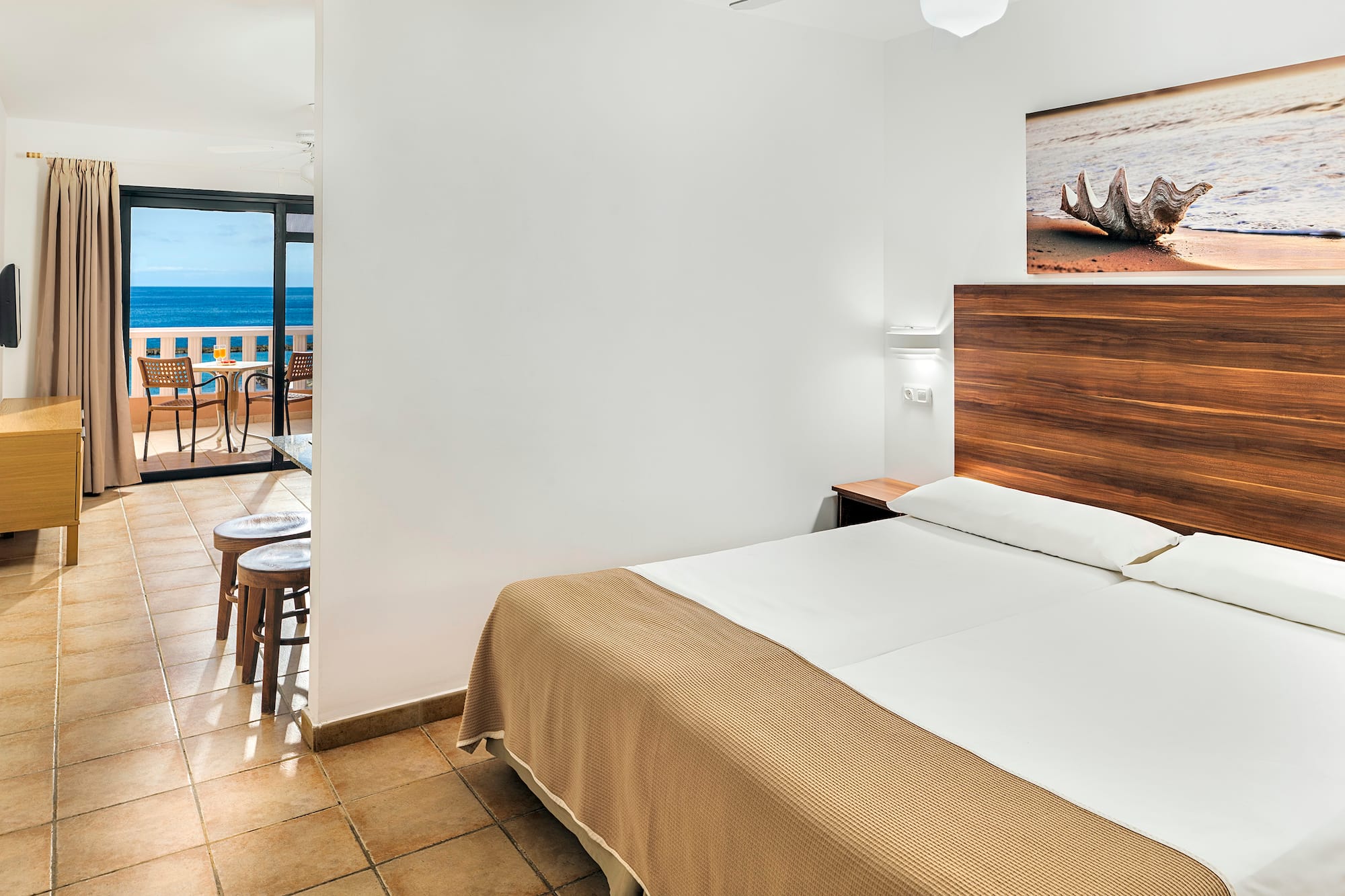 a room with a bed and a view of the ocean