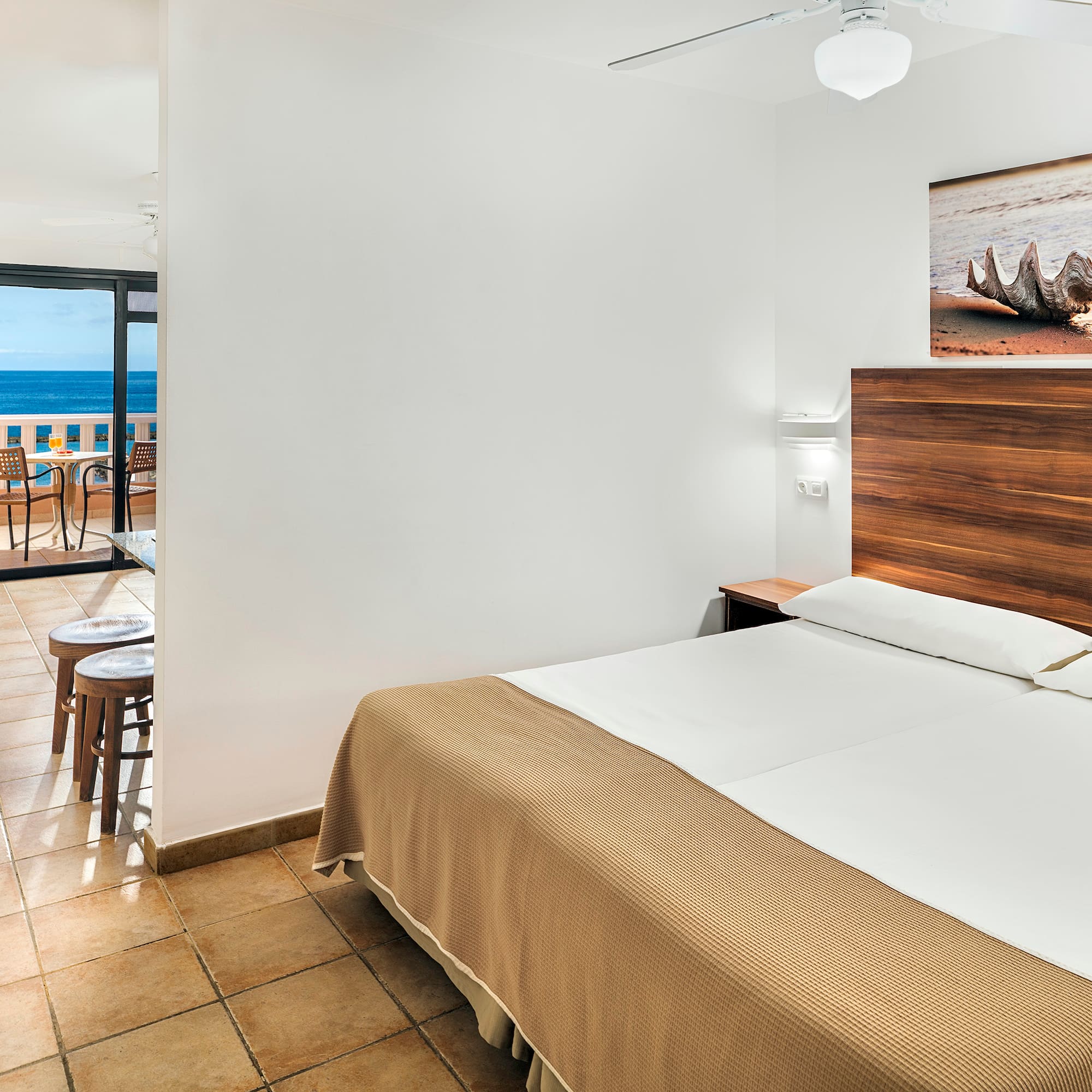 a room with a bed and a view of the ocean