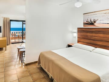 a room with a bed and a view of the ocean