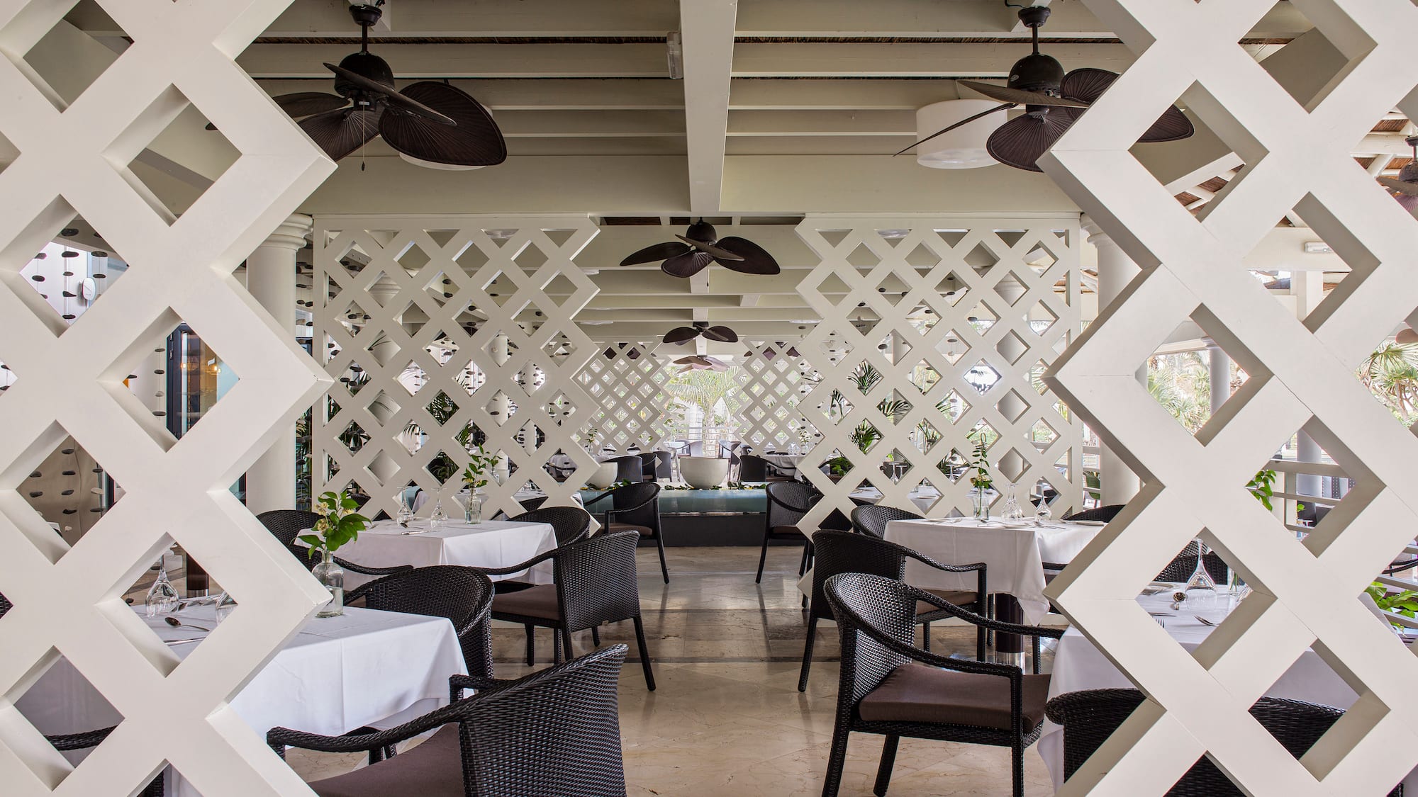 a white latticed restaurant with tables and chairs