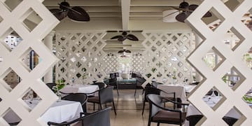 a white latticed restaurant with tables and chairs