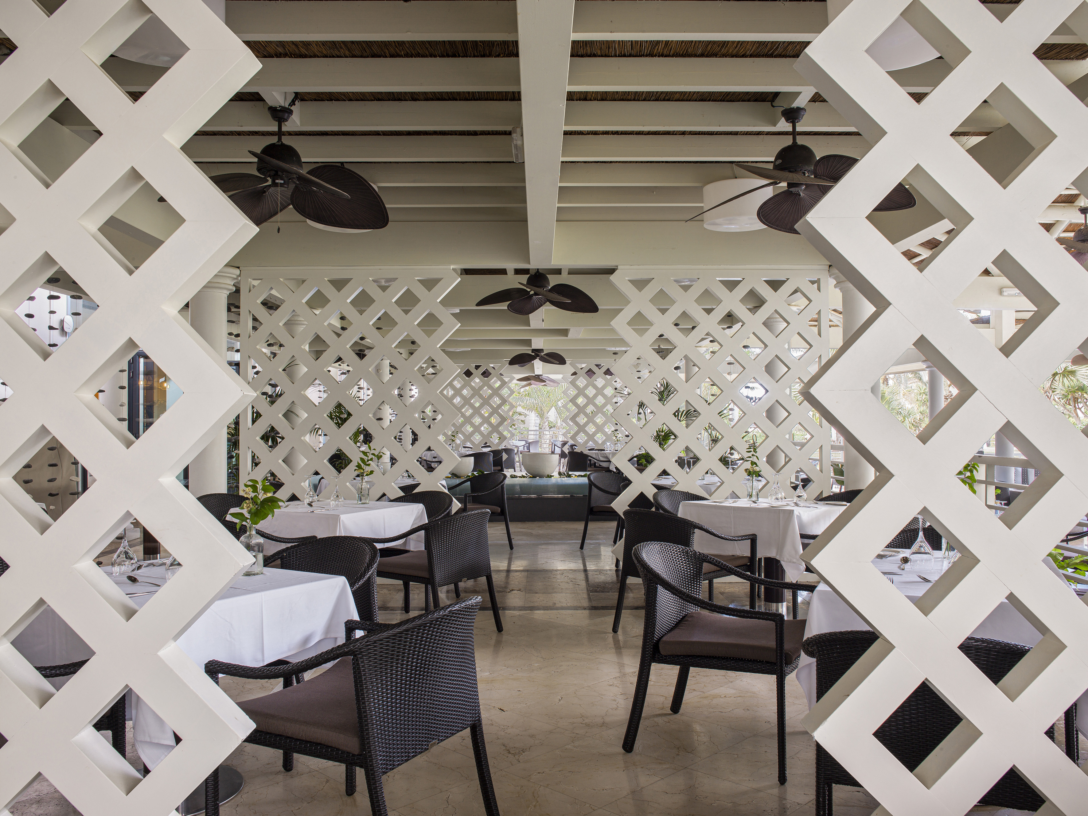a white latticed restaurant with tables and chairs