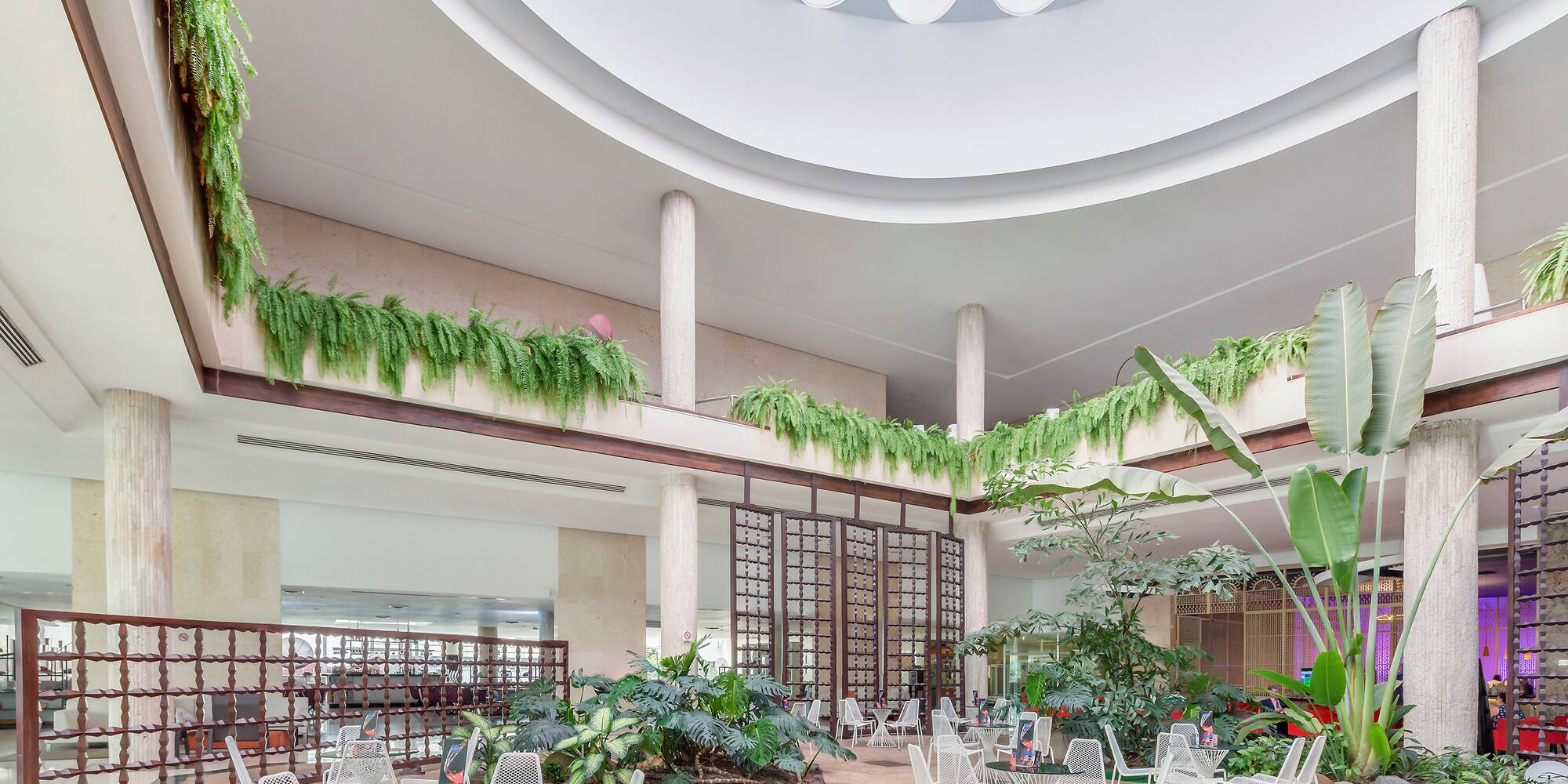 a large indoor courtyard with white chairs and tables