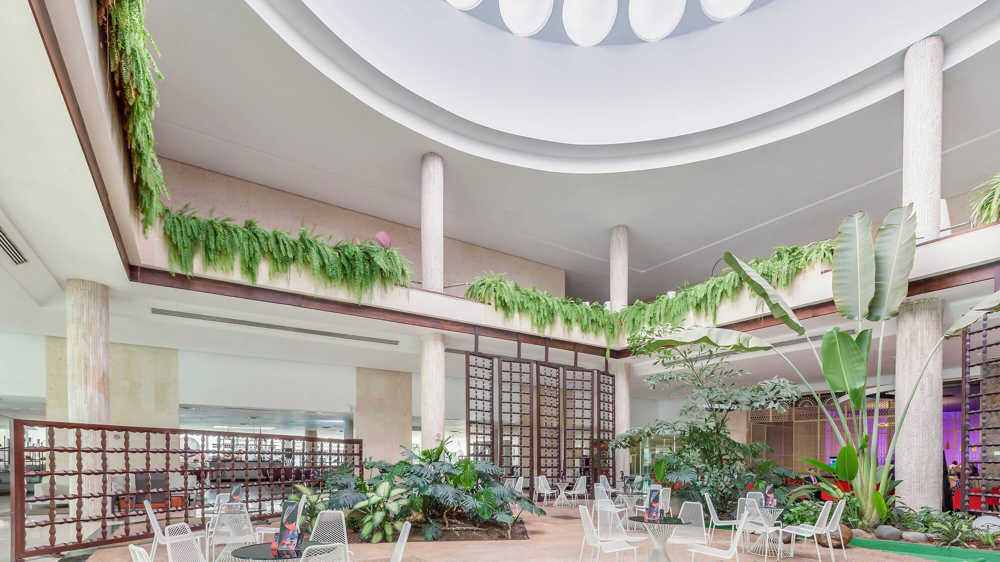 a large indoor courtyard with white chairs and tables