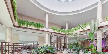 a large indoor courtyard with white chairs and tables