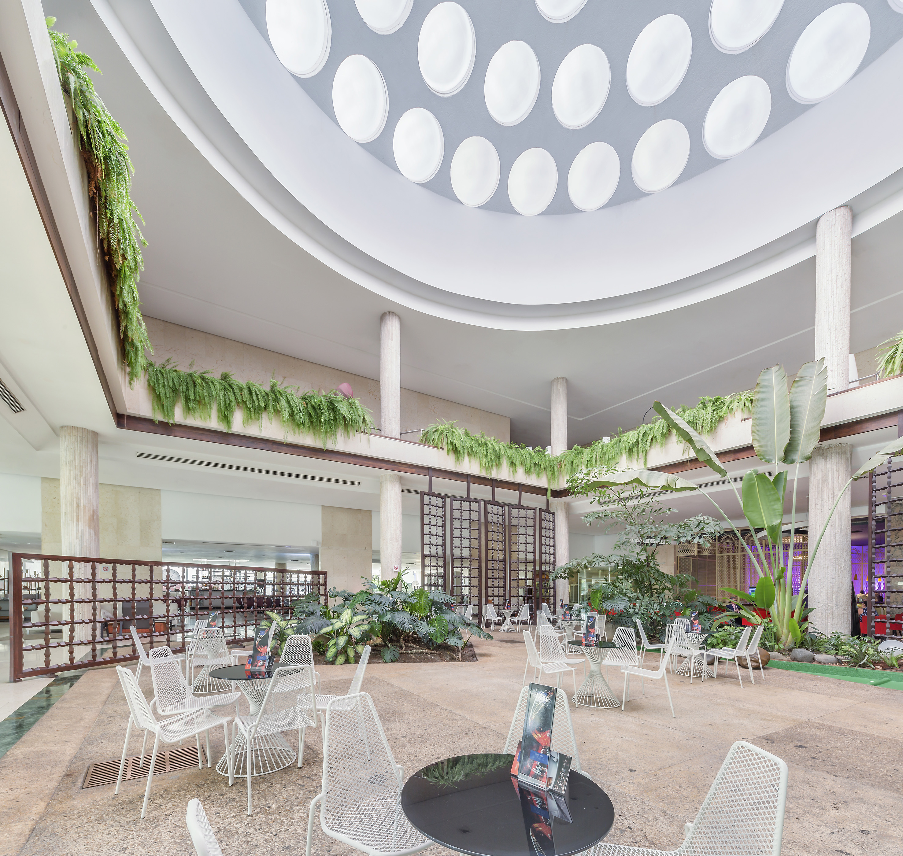 a large indoor courtyard with white chairs and tables