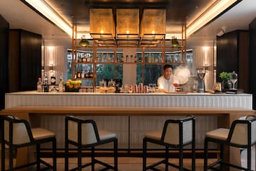 a woman making a drink at a bar