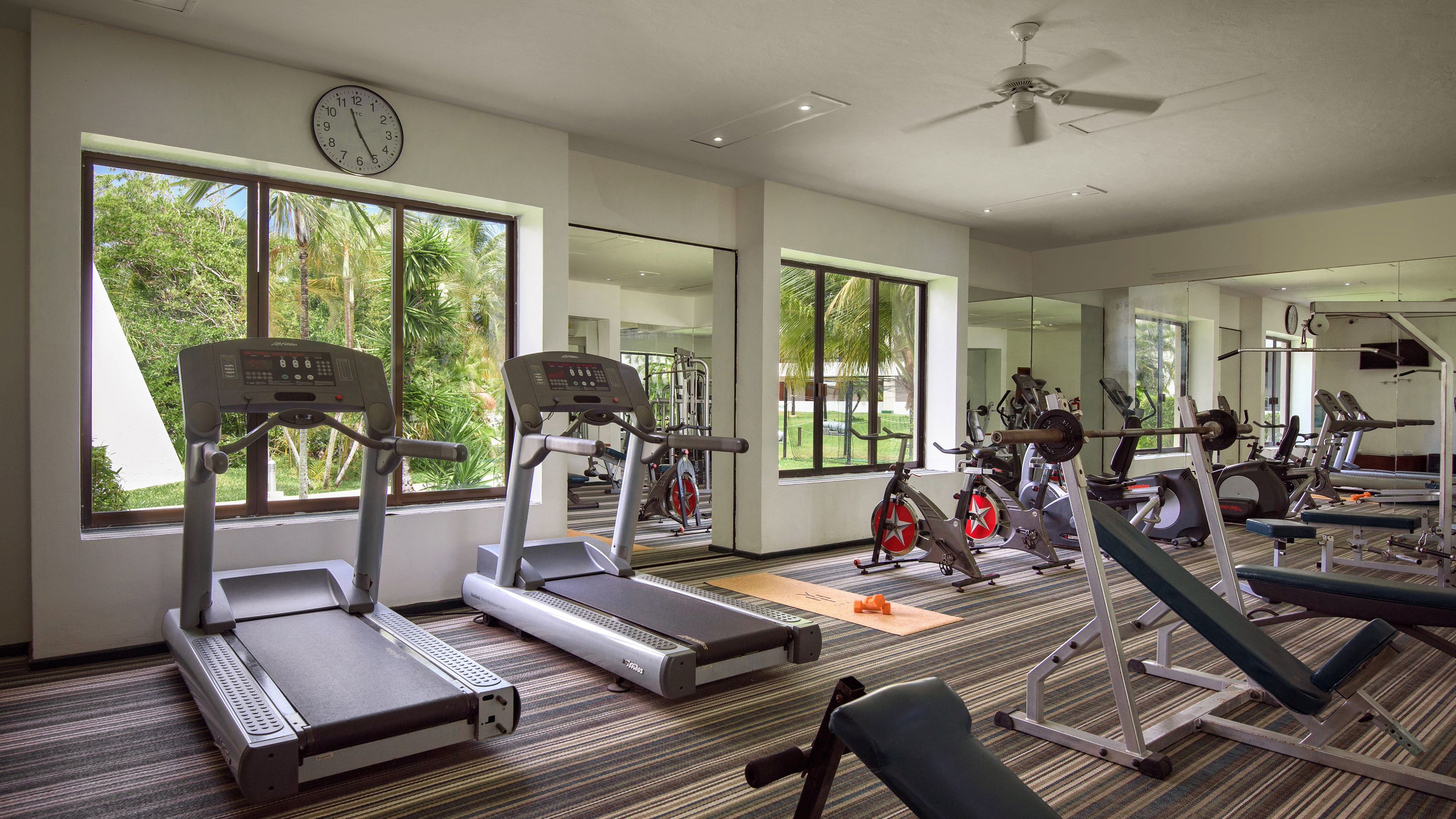 a room with exercise equipment and a clock