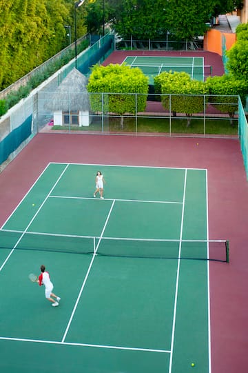 a couple of people playing tennis