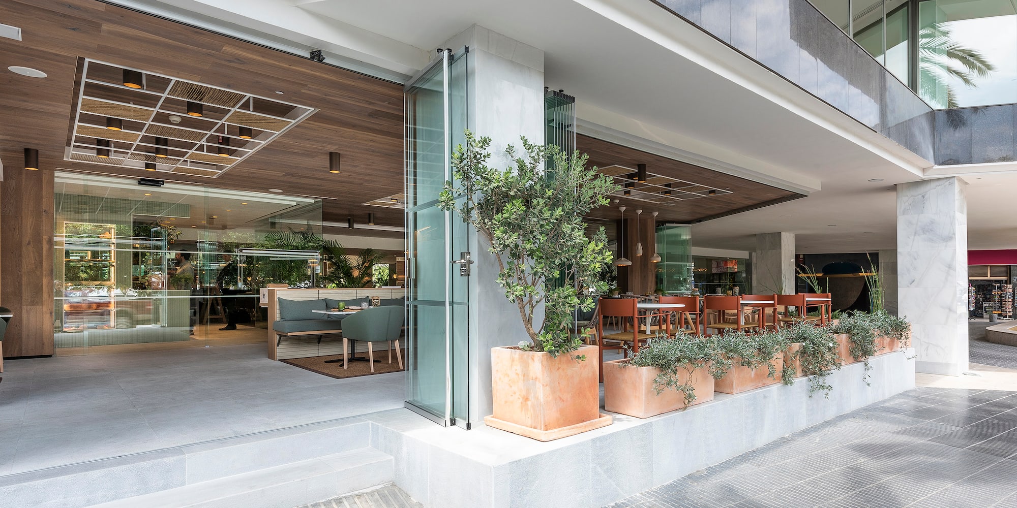 a building with glass doors and a tree