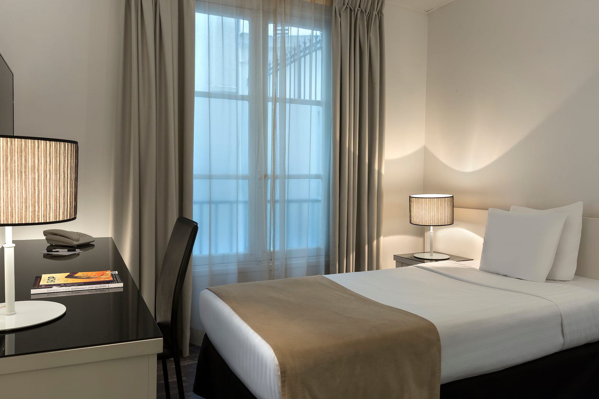 a bed with a desk and lamp in a room