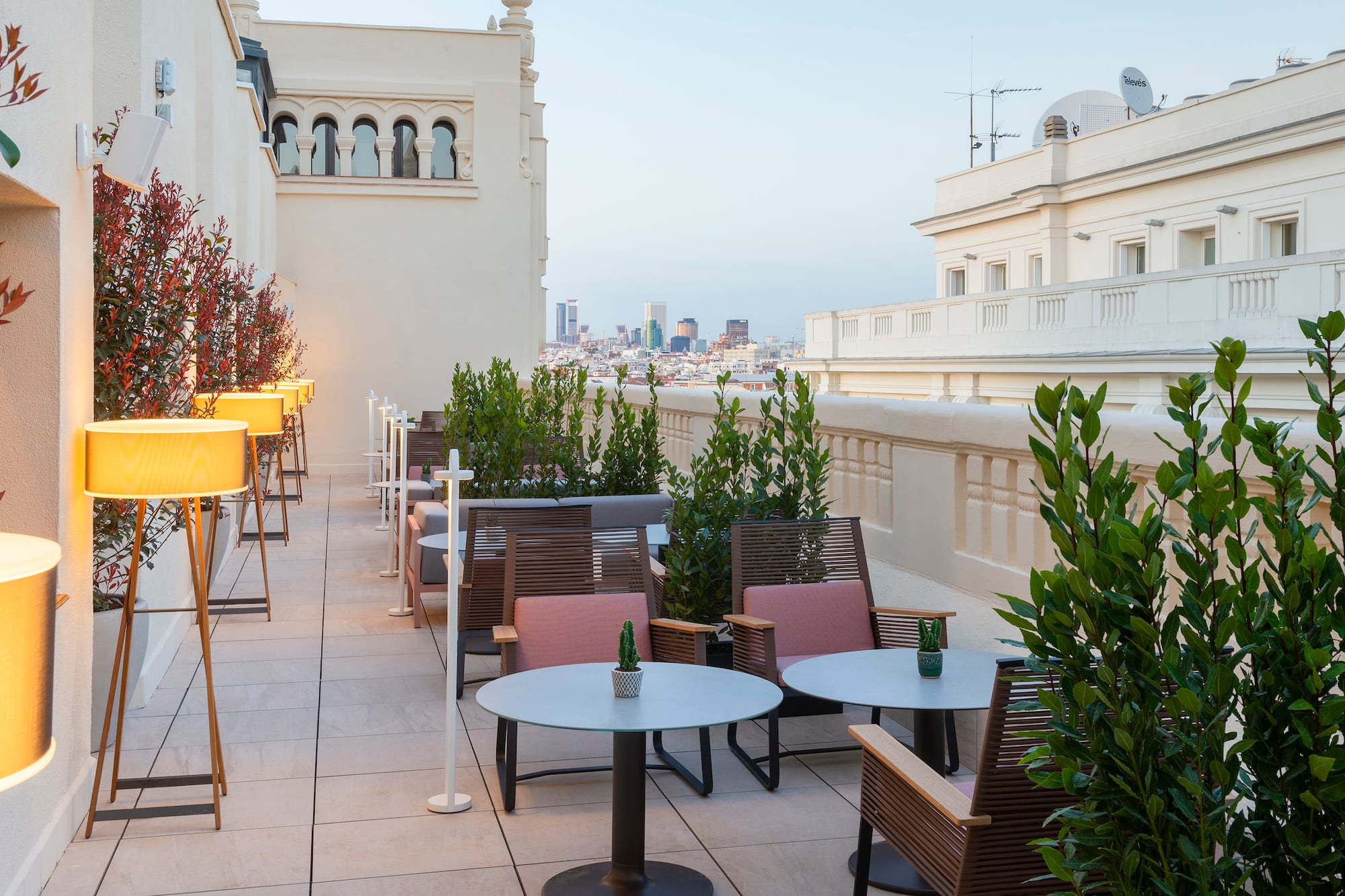 Madrid hotel rooftop terrace with modern outdoor seating and city views.