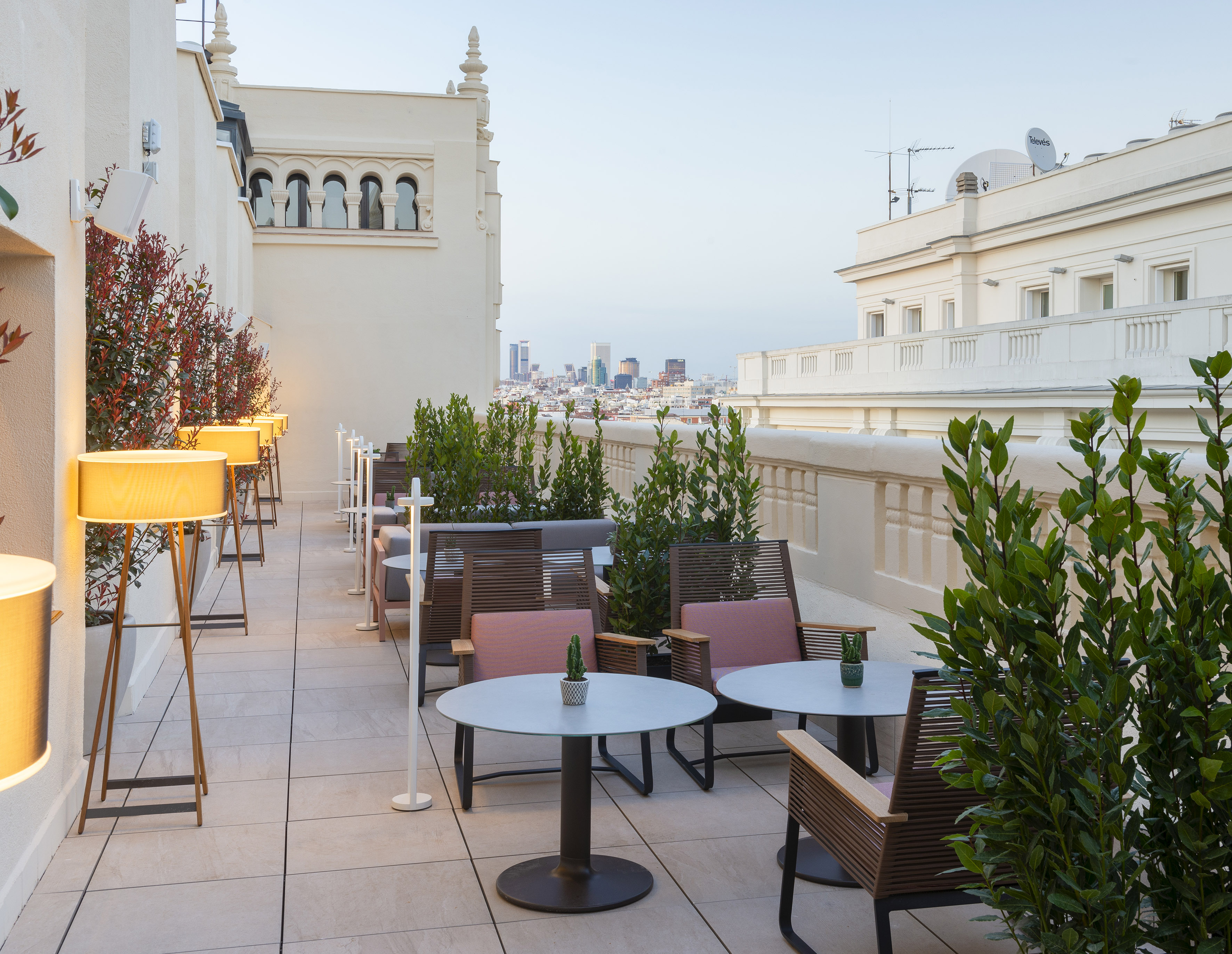 Madrid hotel rooftop terrace with modern outdoor seating and city views.