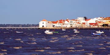 a body of water with boats and buildings in the background