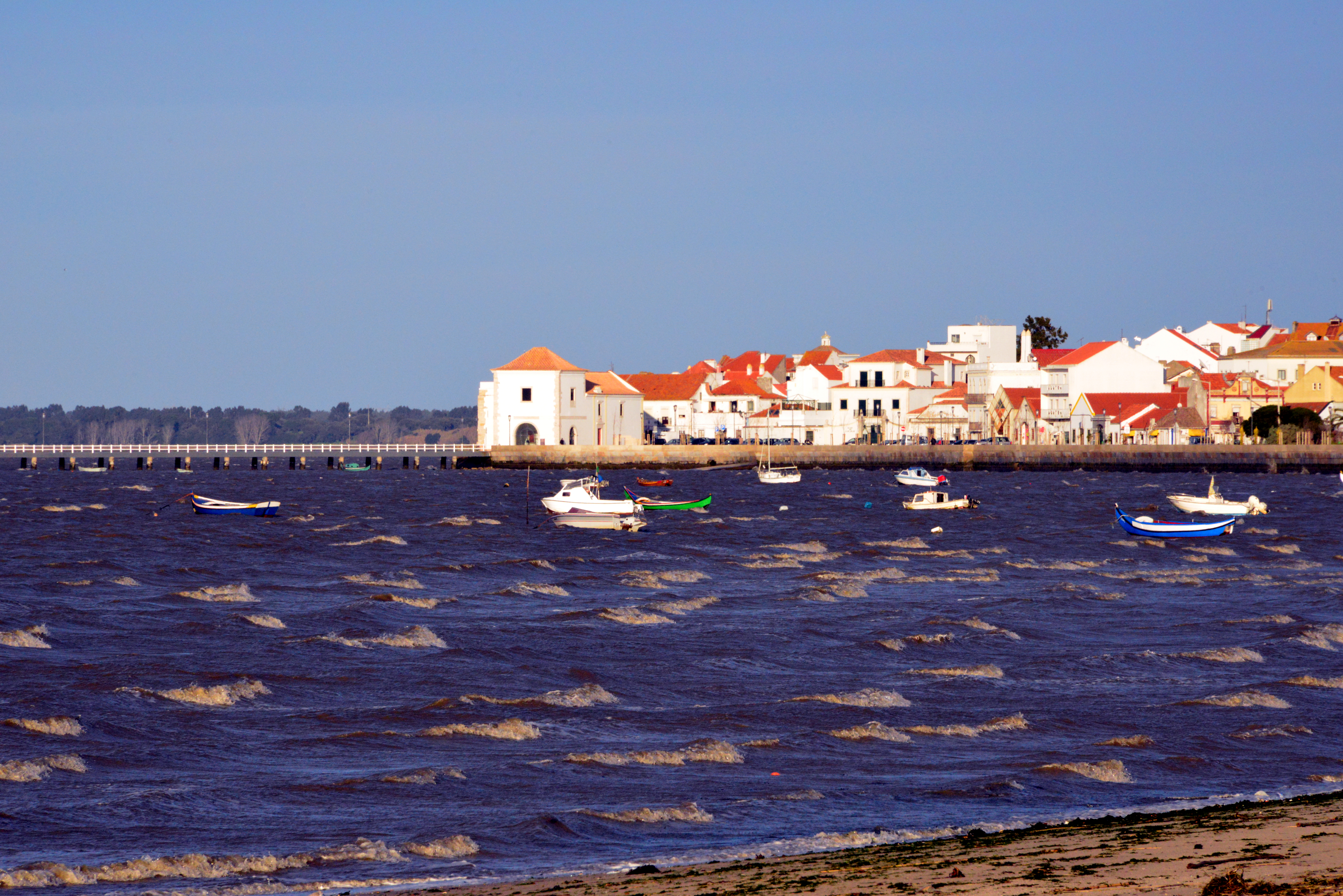 a body of water with boats and buildings in the background