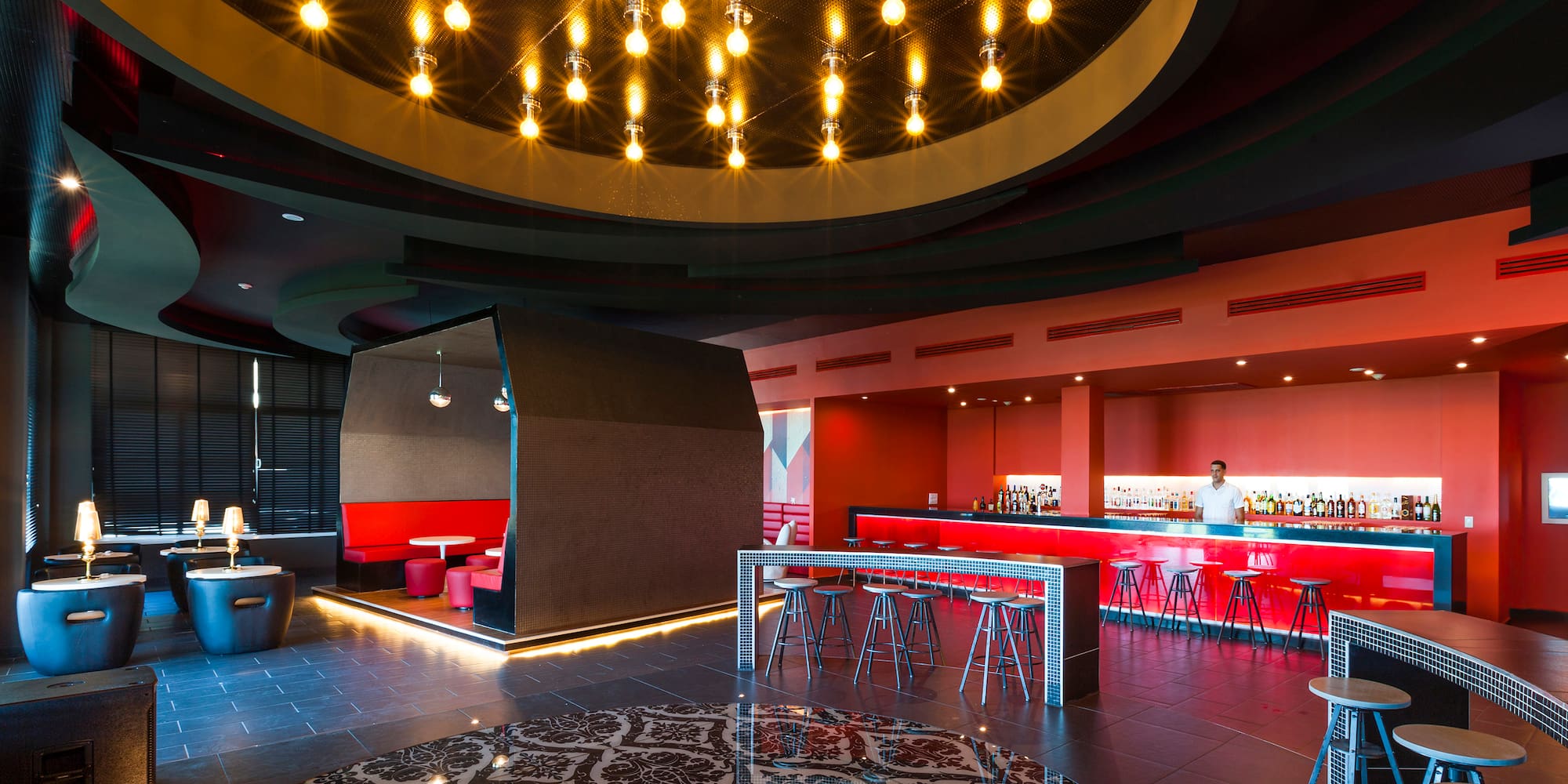 a room with a bar and a man standing behind a bar