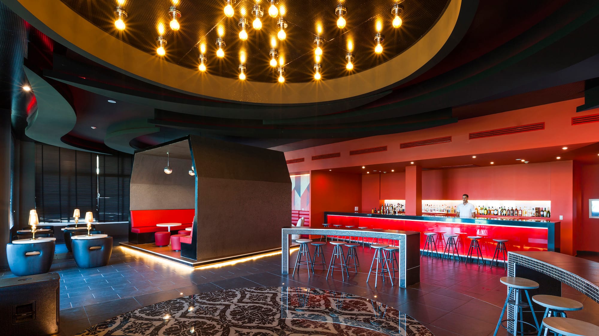 a room with a bar and a man standing behind a bar