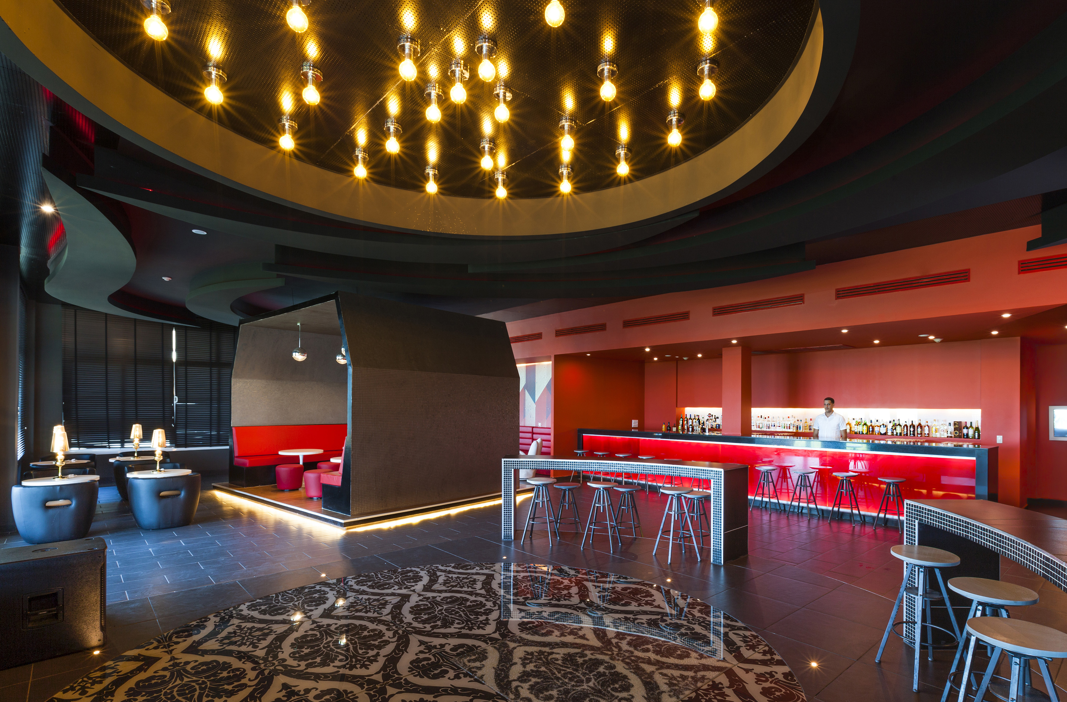 a room with a bar and a man standing behind a bar