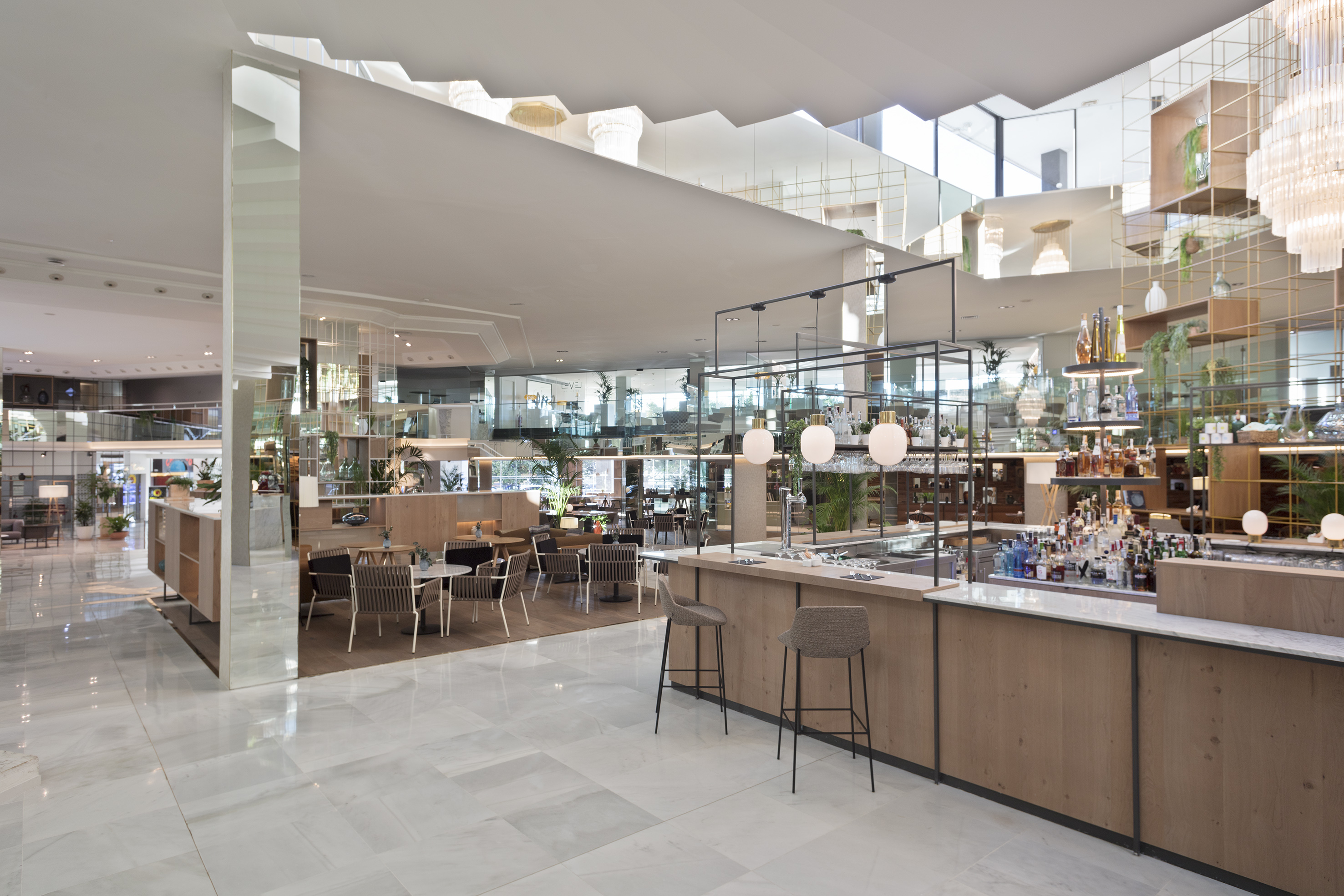 Modern hotel lobby bar and lounge with contemporary decor and plants.