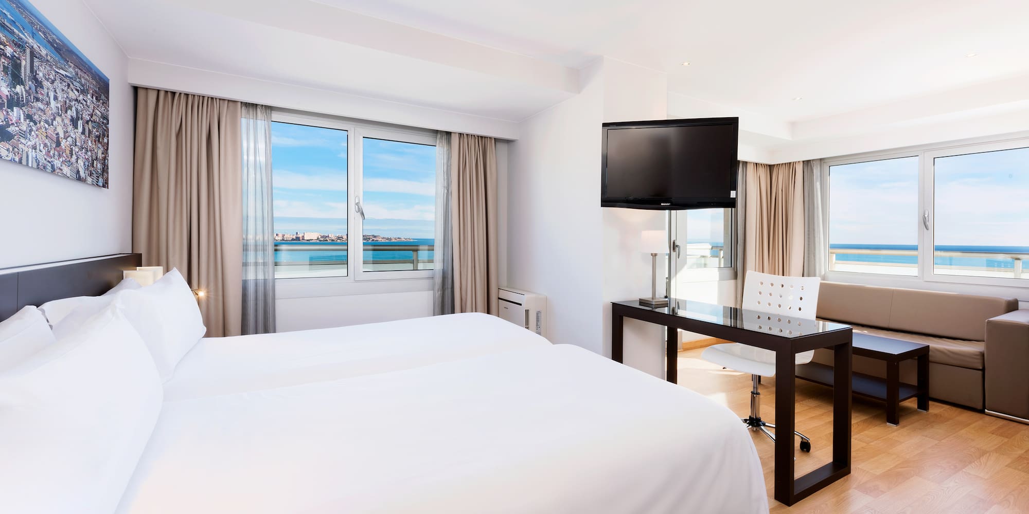 a room with a bed and a table and a television