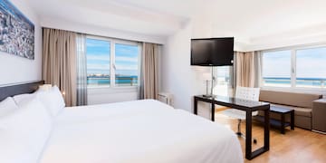 a room with a bed and a table and a television