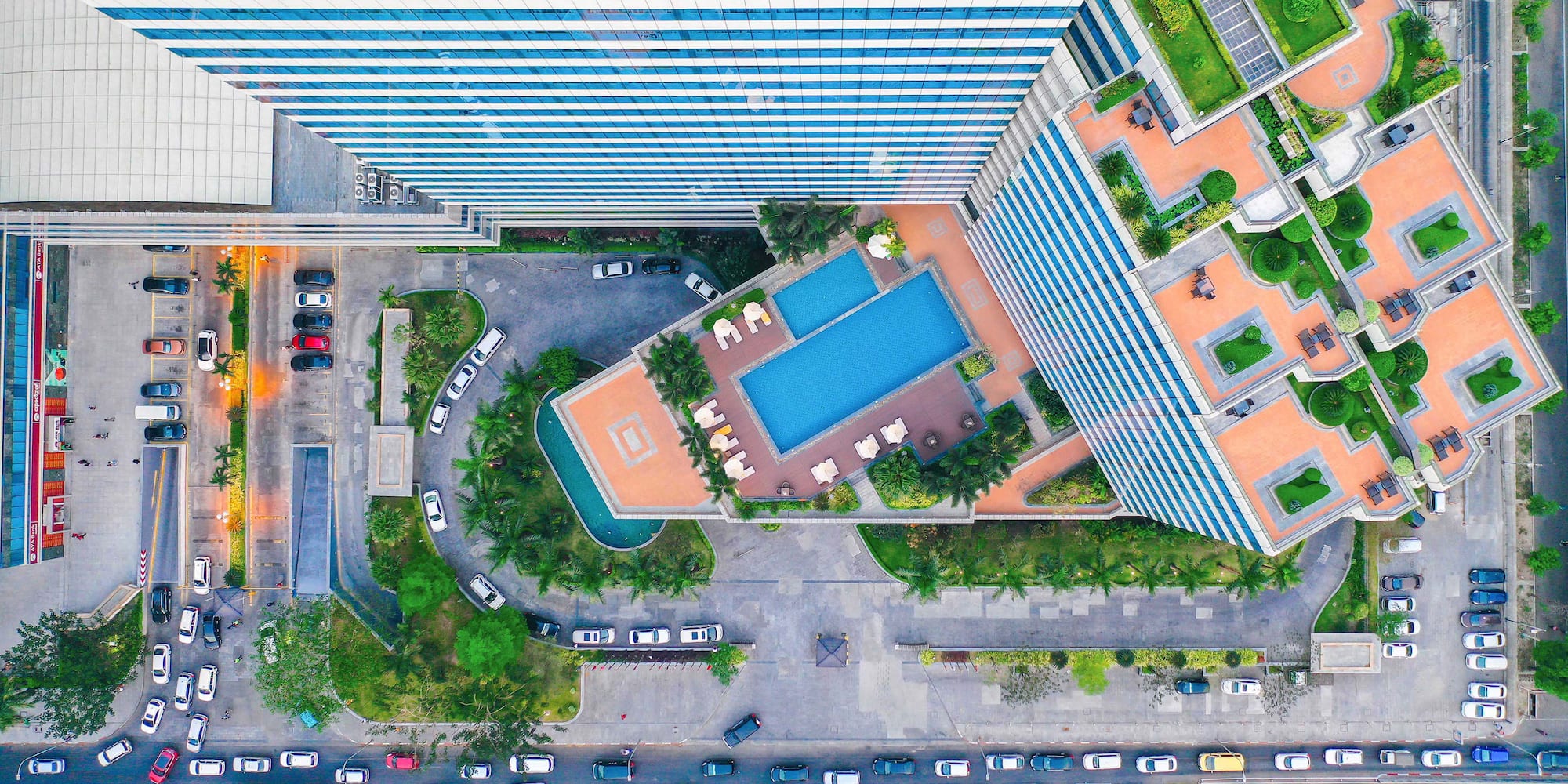 a high angle view of a building with a pool and cars