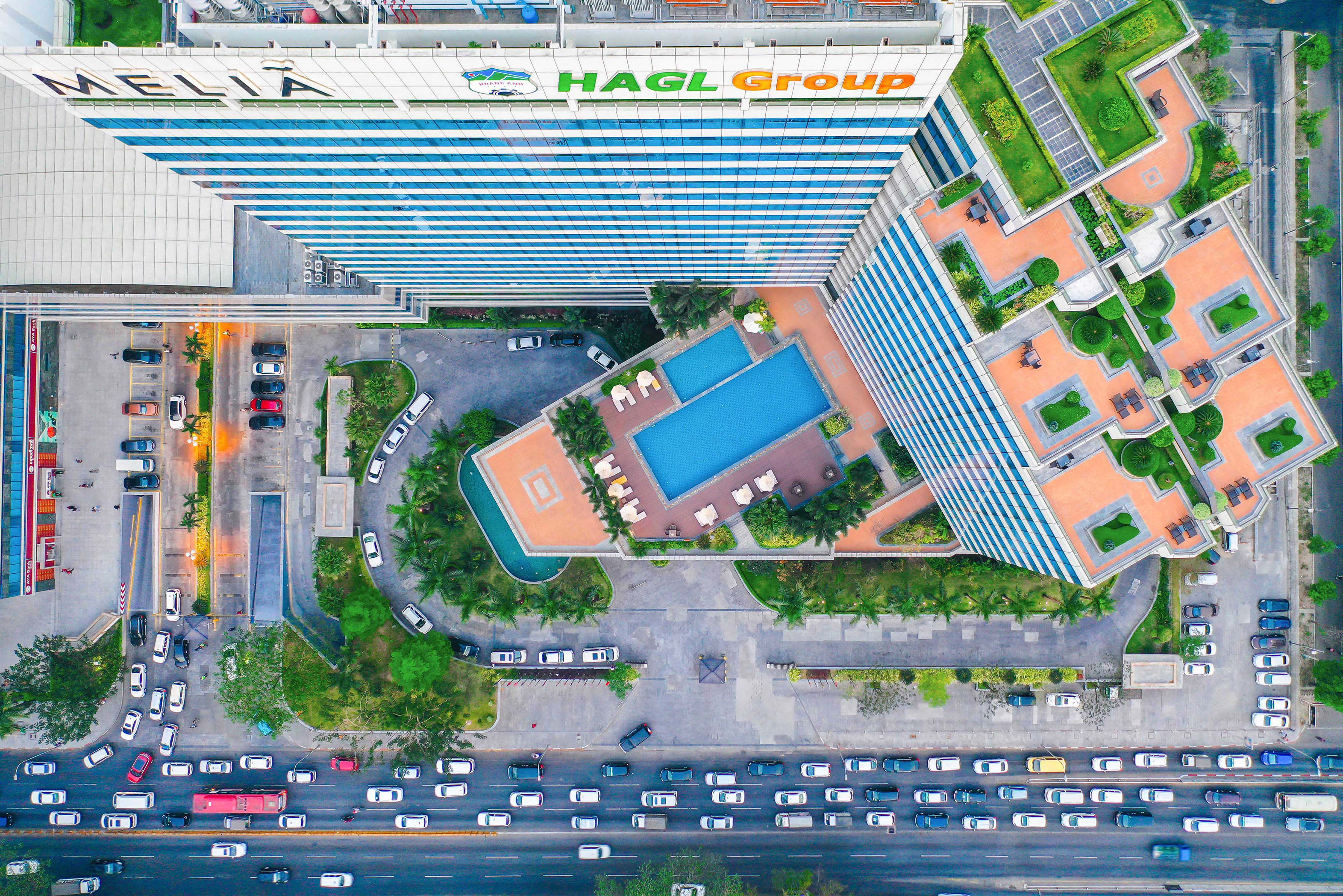 a high angle view of a building with a pool and cars