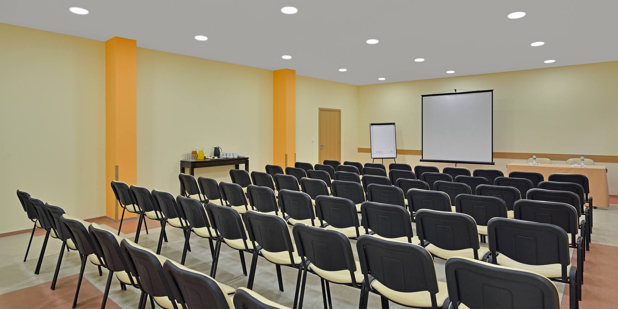 a room with many chairs and a projector screen