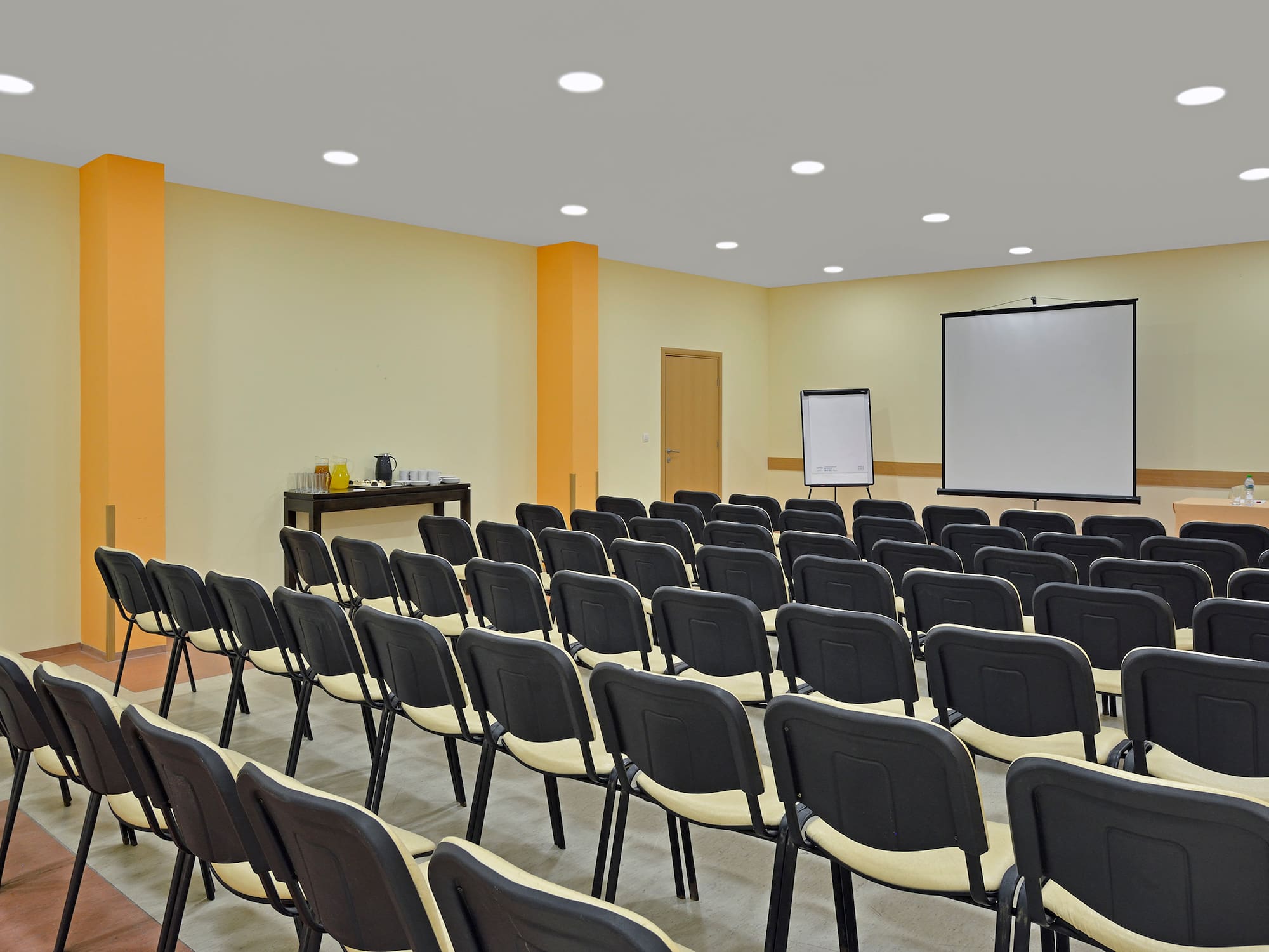 a room with many chairs and a projector screen