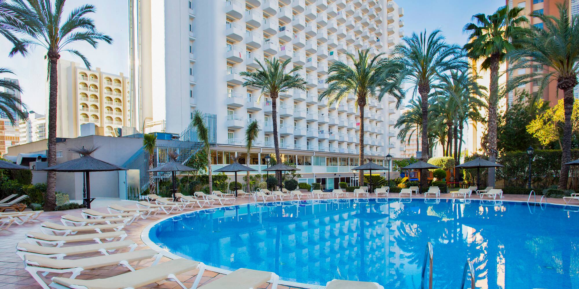 a pool with lounge chairs and palm trees