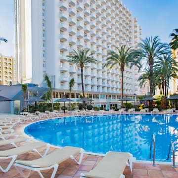 a pool with lounge chairs and palm trees