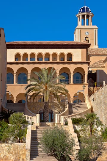 a building with palm trees and a clock tower