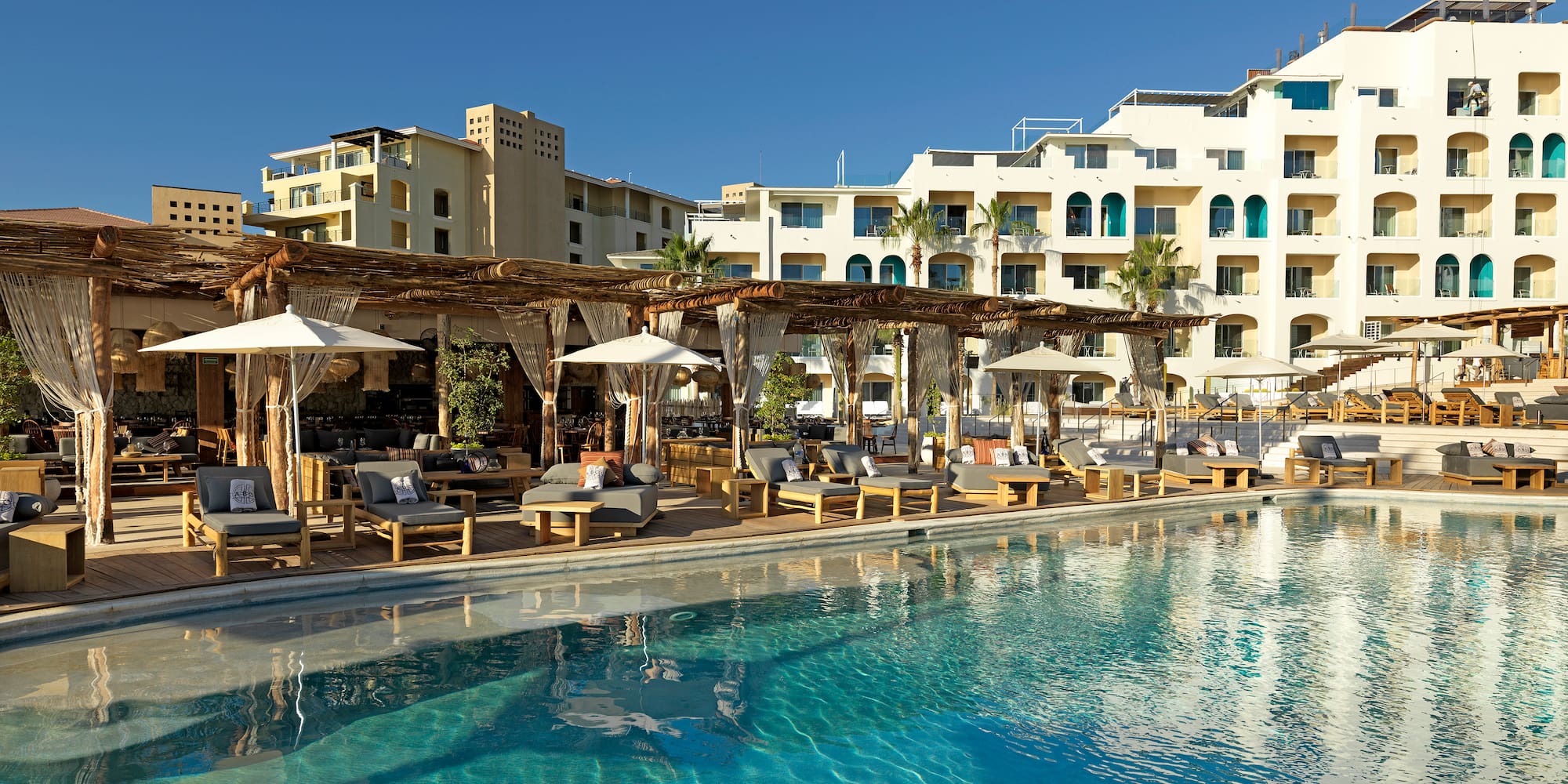 a pool with lounge chairs and umbrellas