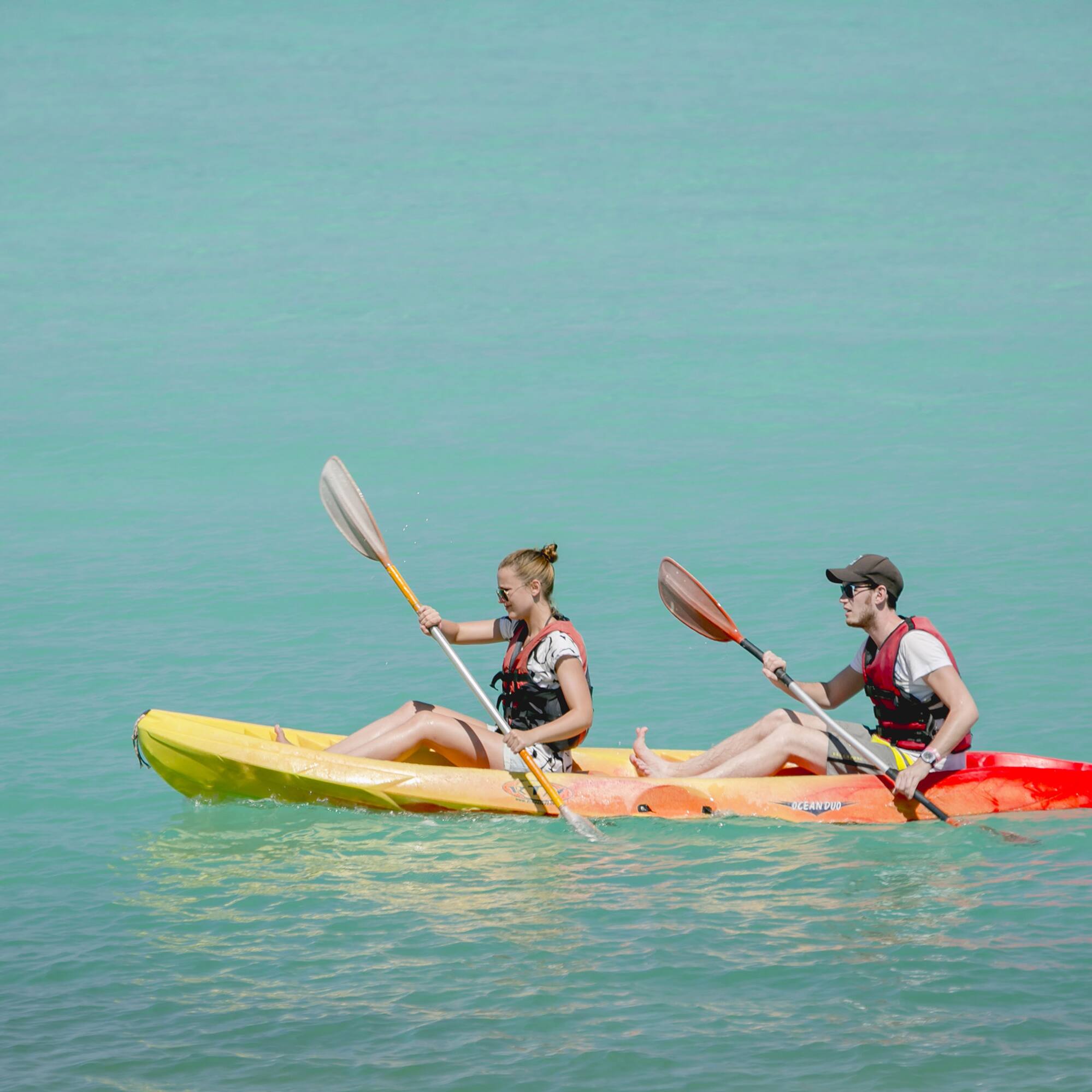 a man and woman in kayaks on the water