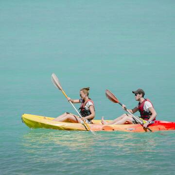 a man and woman in kayaks on the water