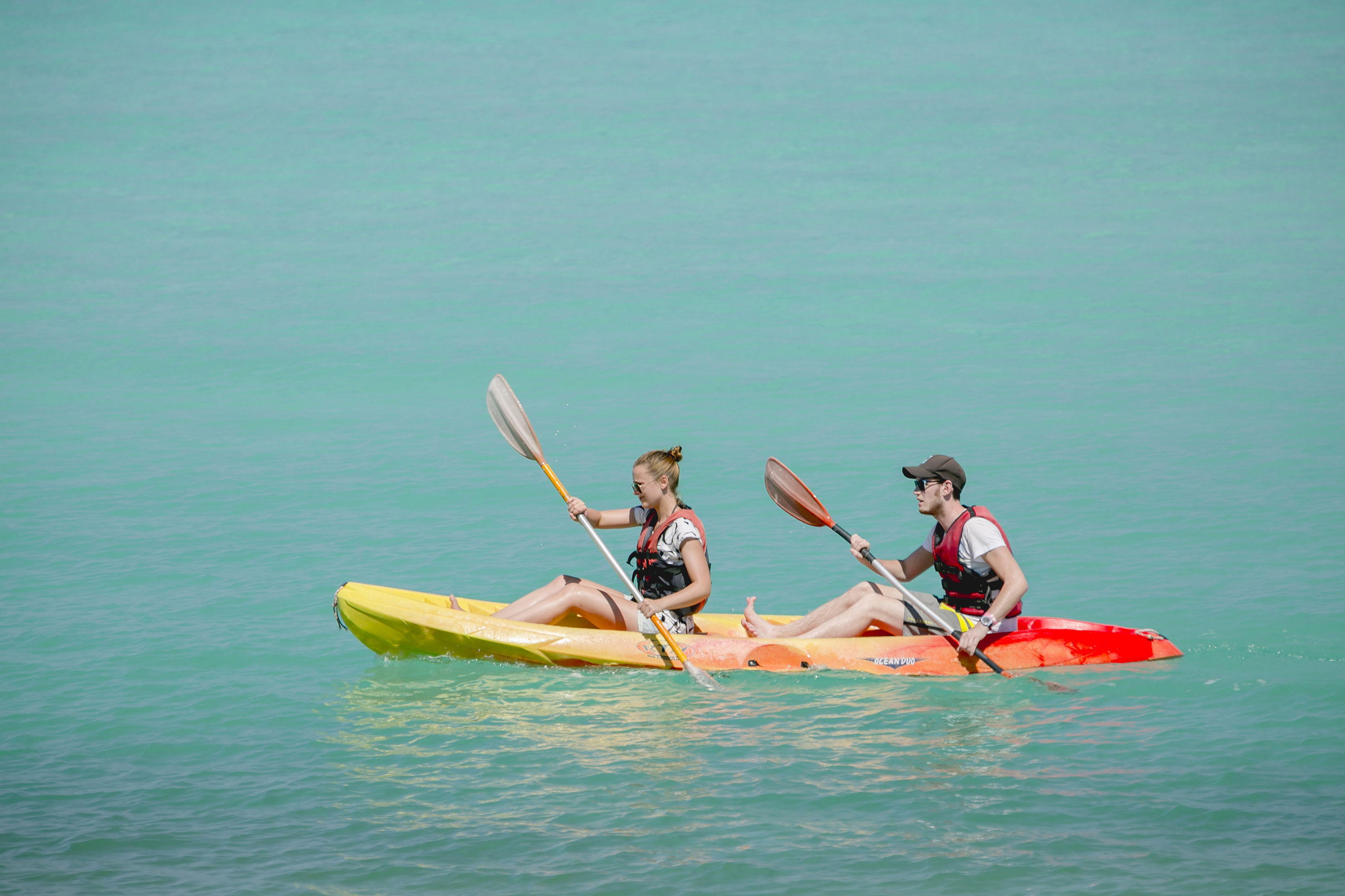 a man and woman in kayaks on the water
