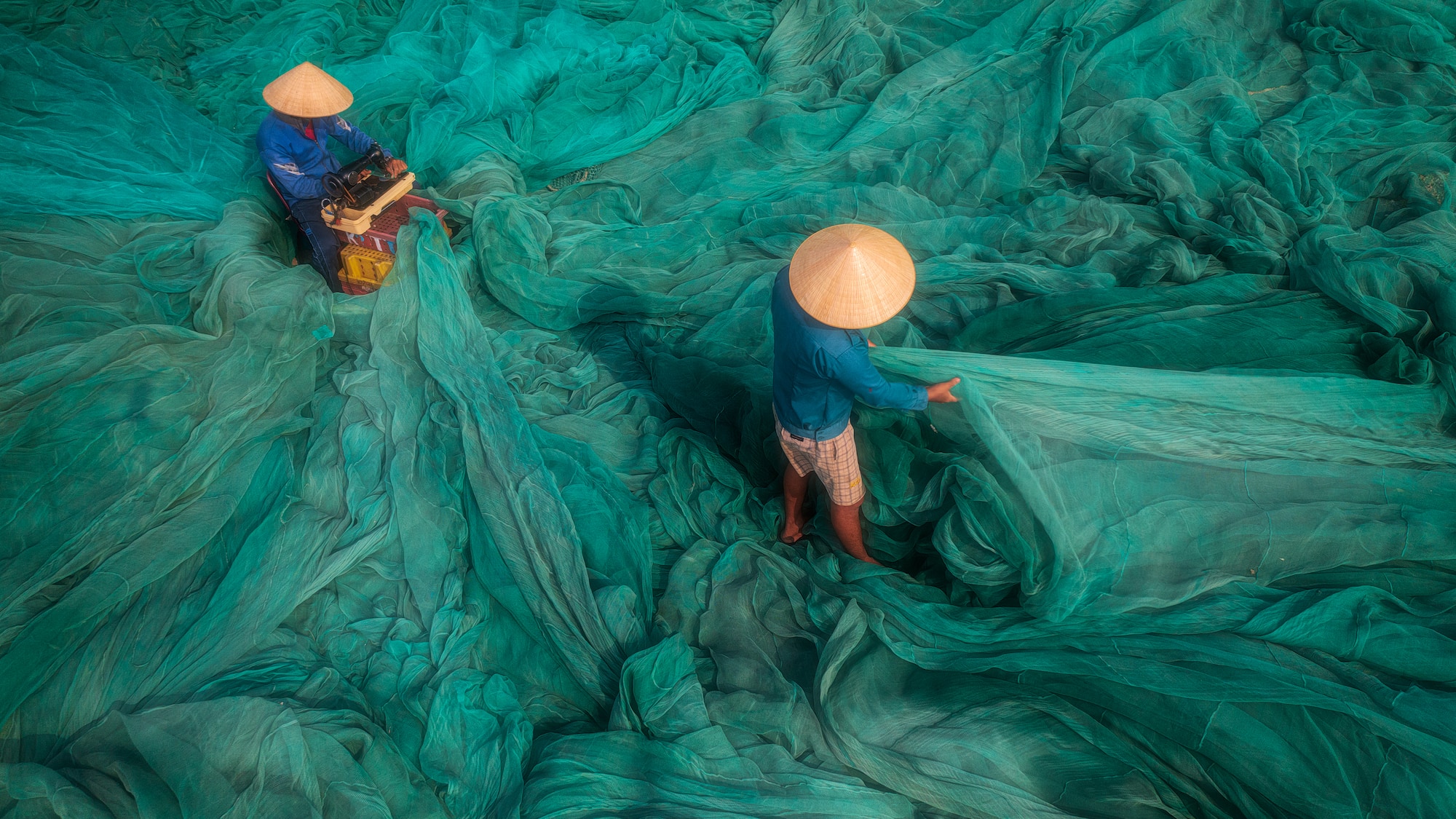 a group of people working on a large green net