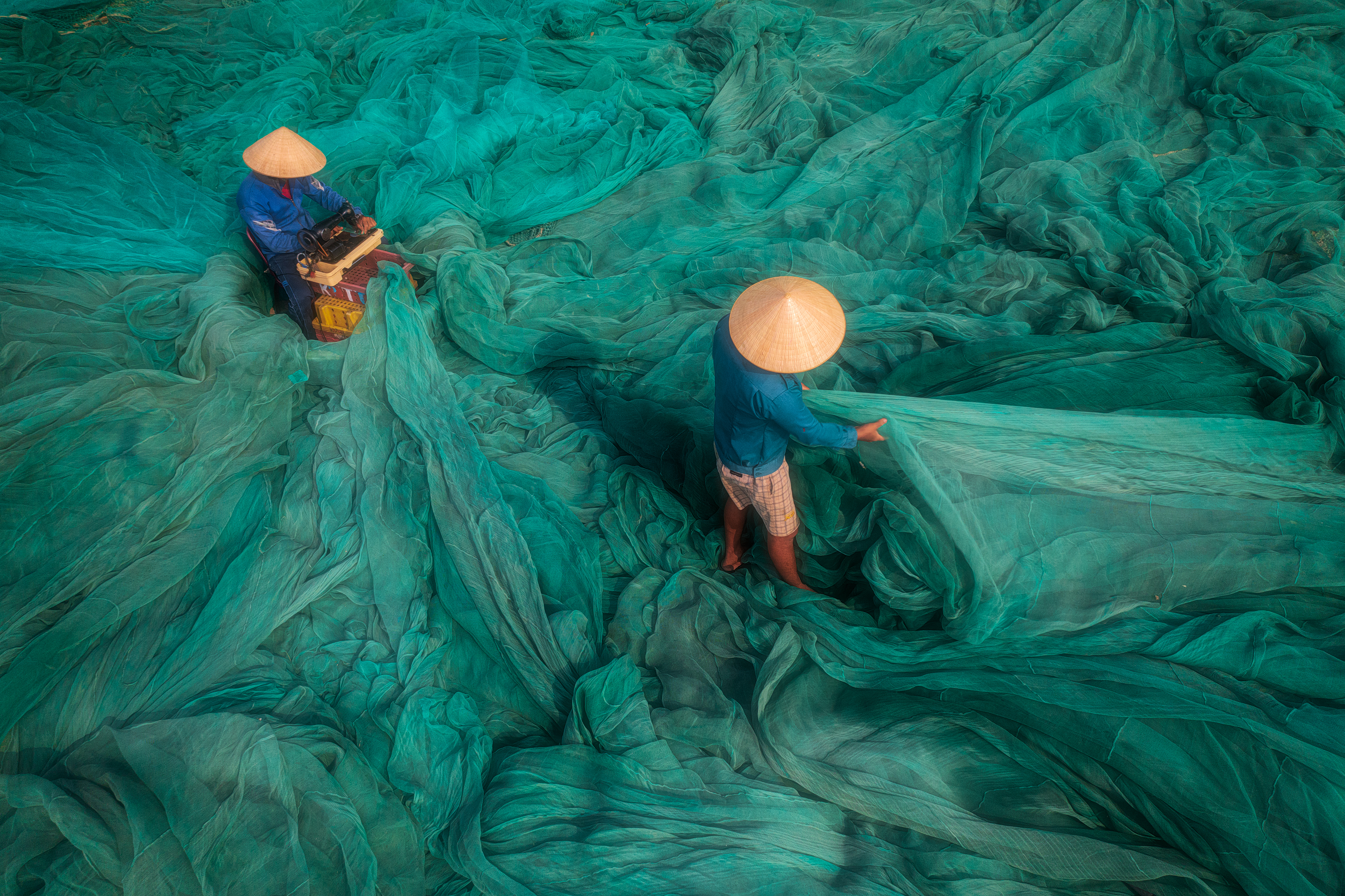 a group of people working on a large green net