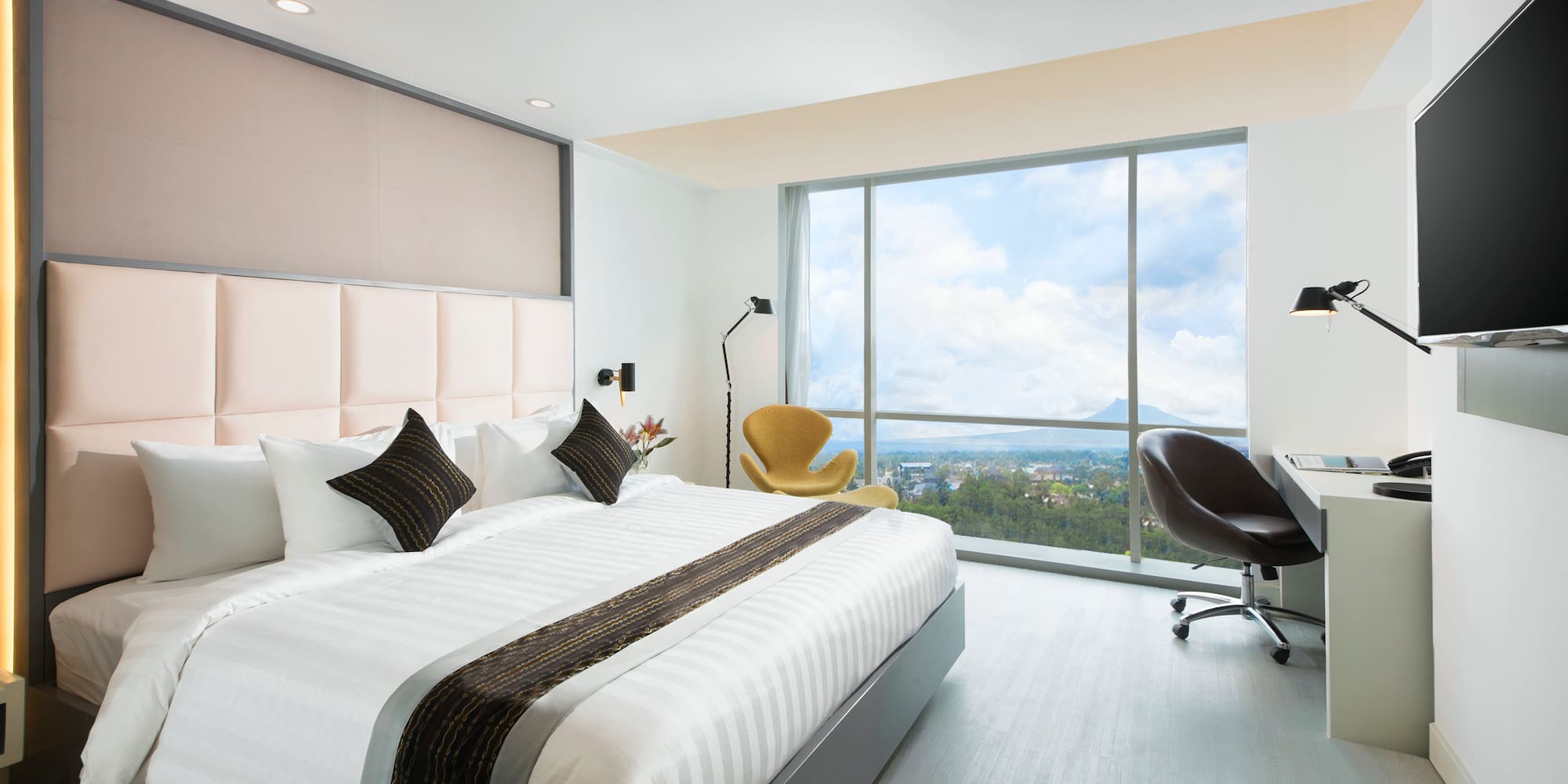 a bedroom with a large window and a large bed