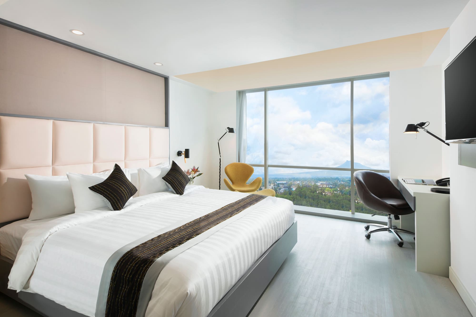 a bedroom with a large window and a large bed