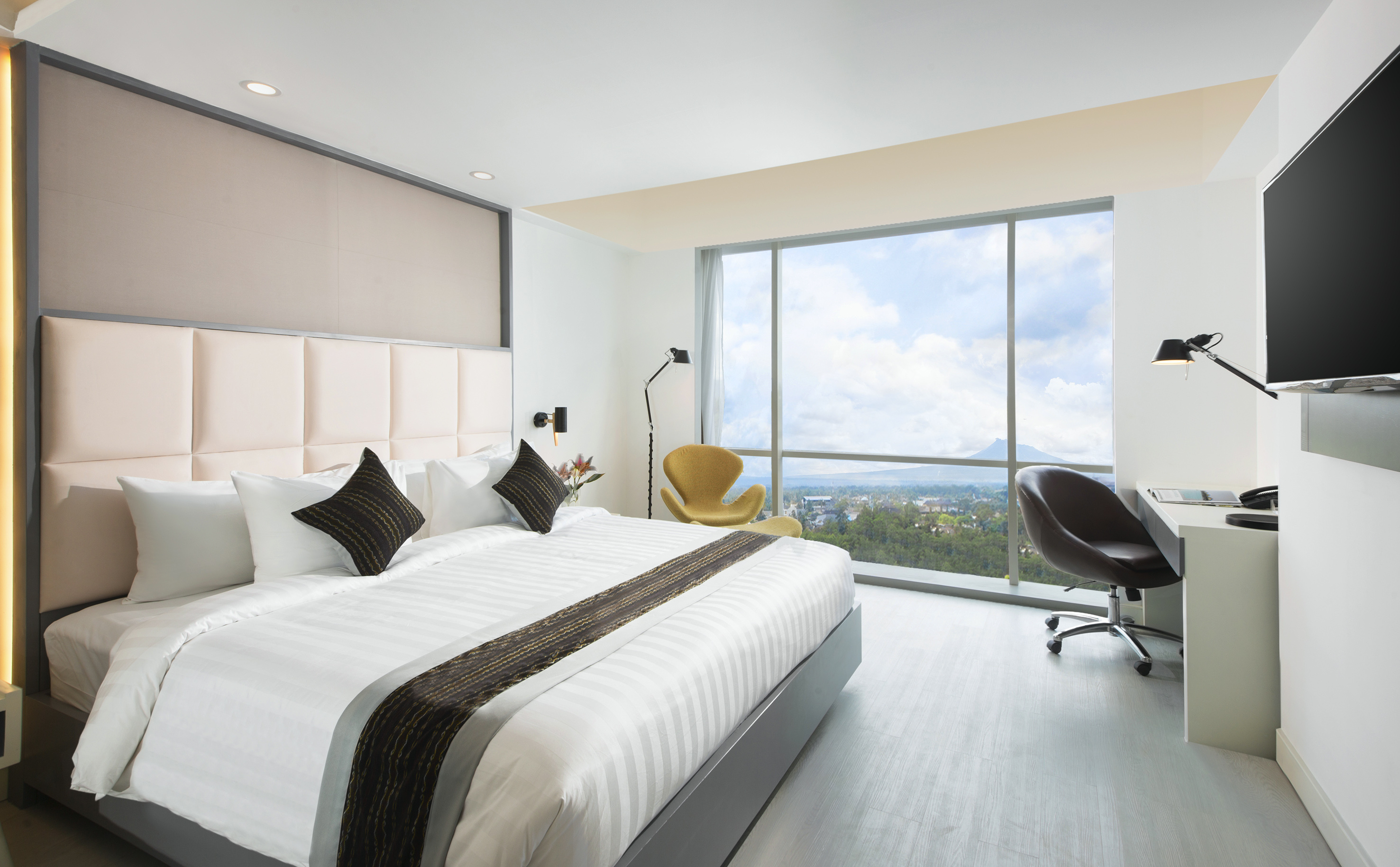 a bedroom with a large window and a large bed