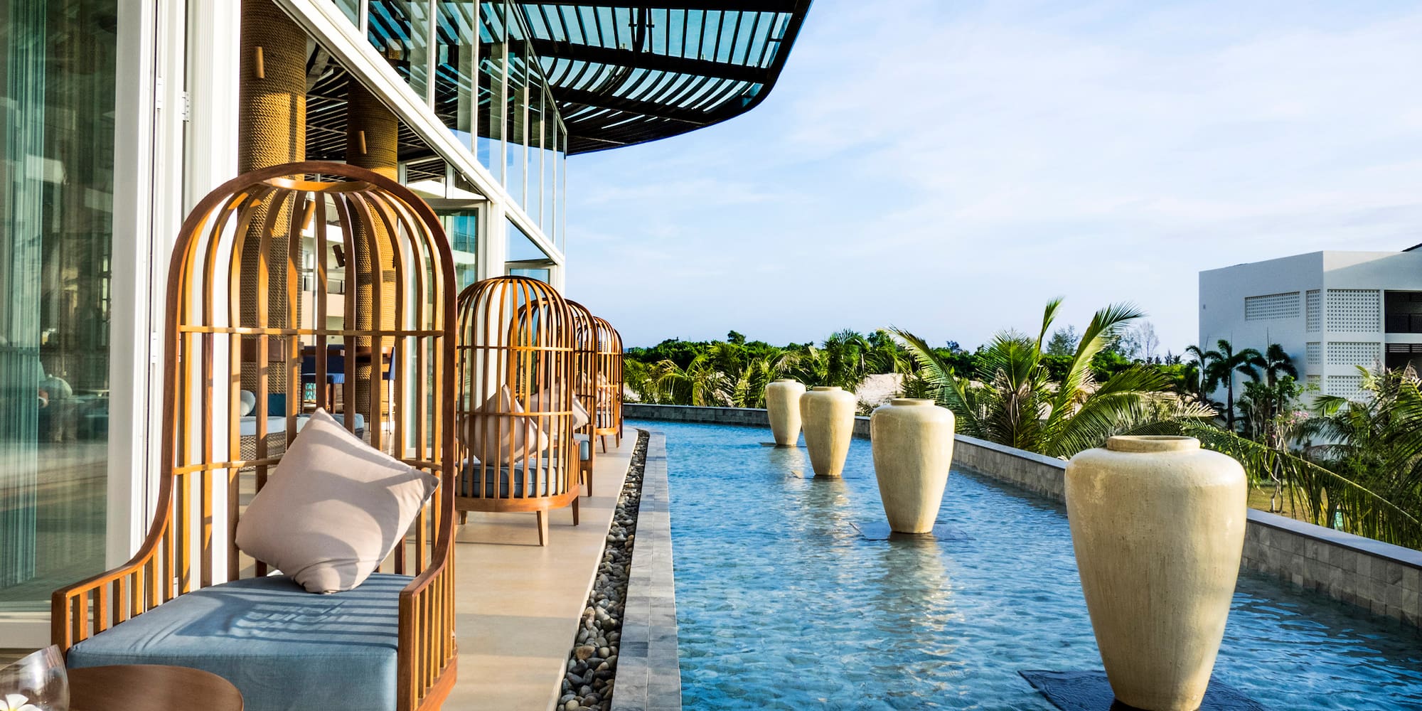 a pool of water with chairs and large vases