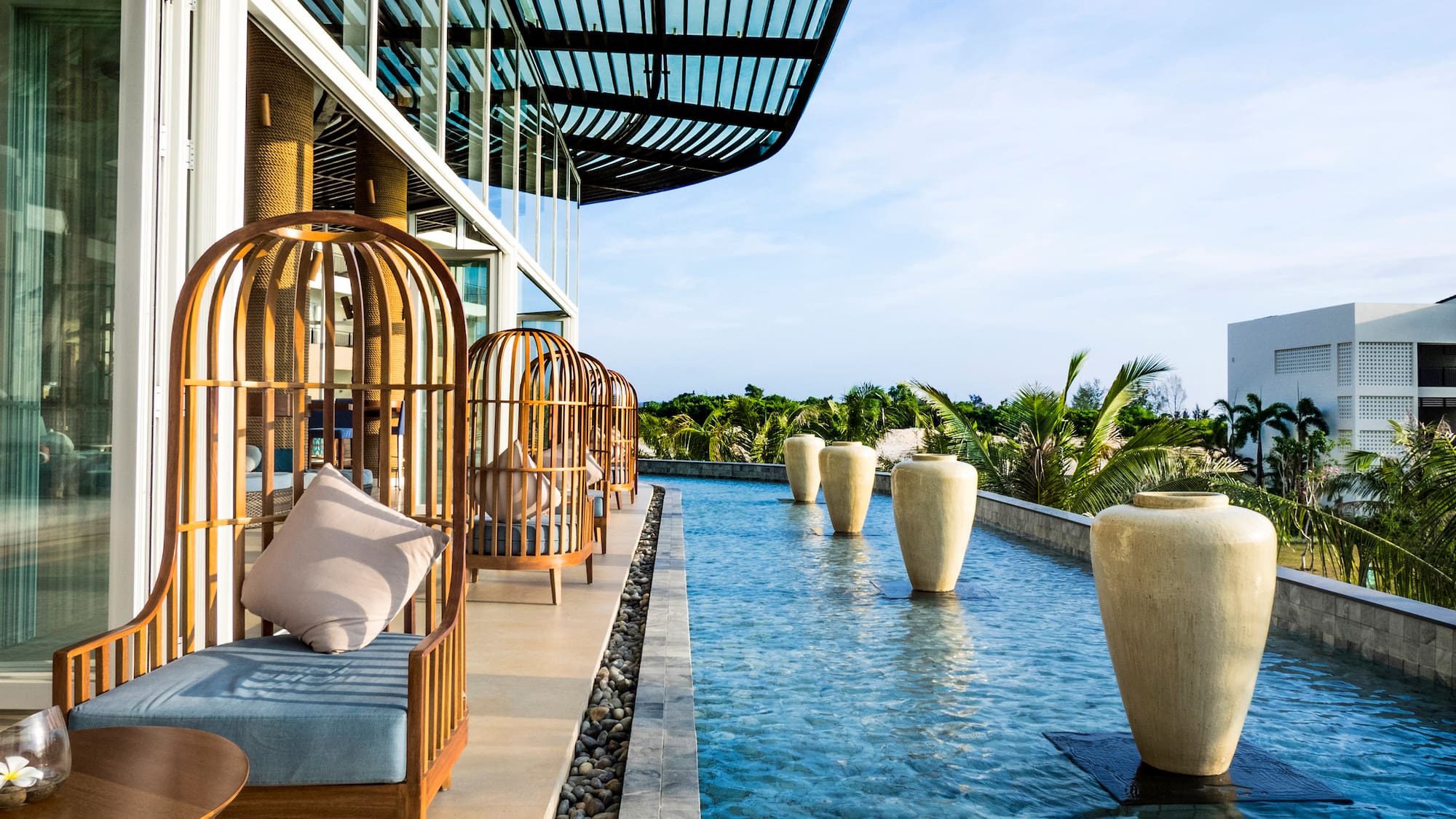 a pool of water with chairs and large vases
